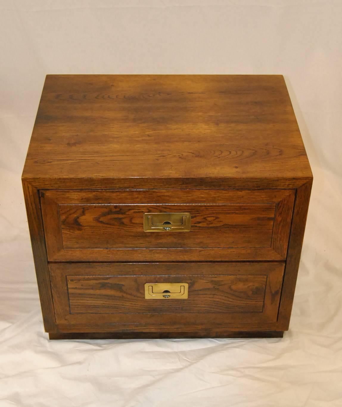 A fantastic pair of Henredon campaign style nightstands. They feature a beautifully grained walnut finish, brass Campaign style hardware and dovetailed drawers. Marked on the inside drawer with the Henredon name. Excellent quality and craftsmanship.