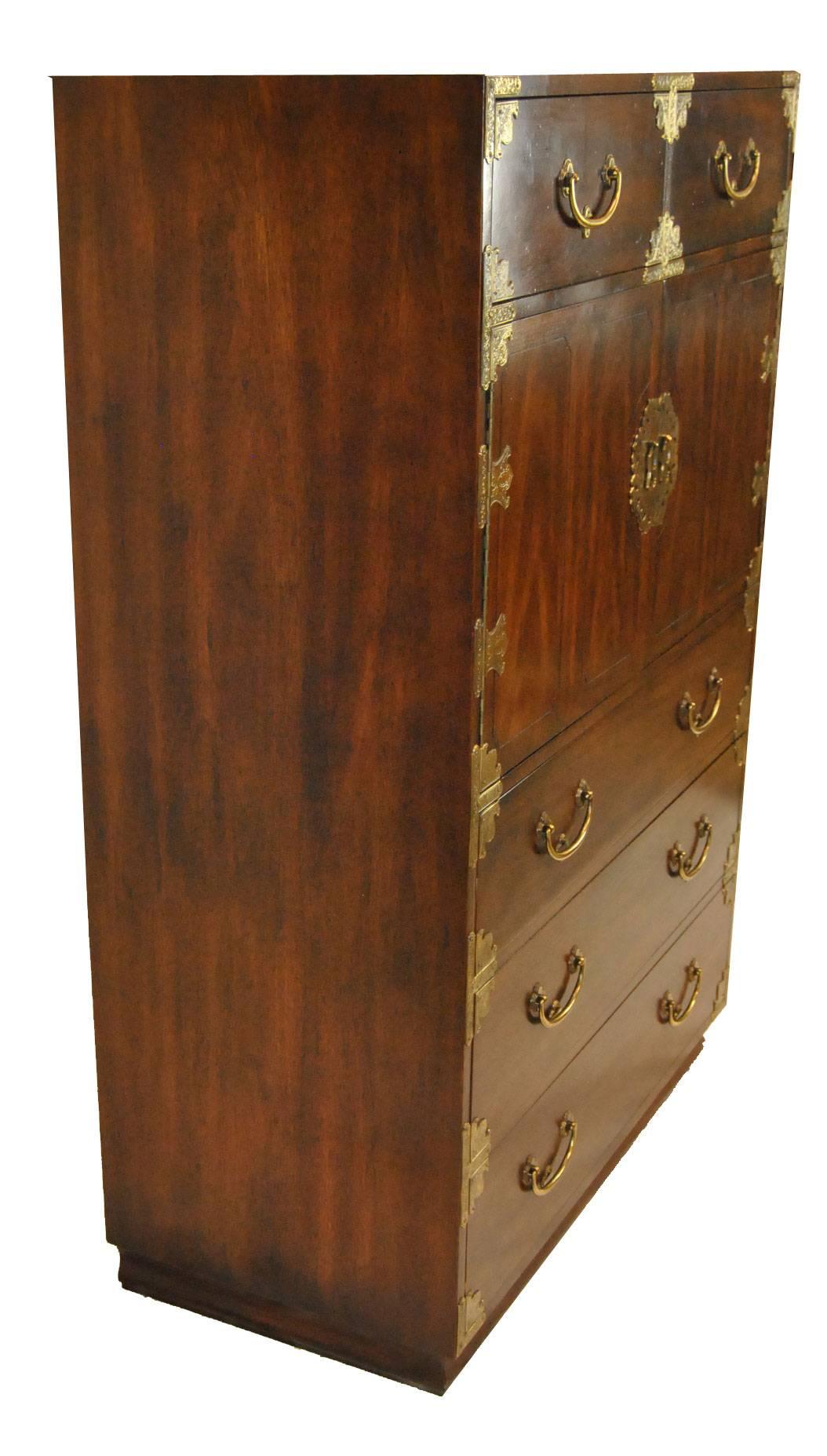 A great dark stained mahogany gentlemen's chest by Henredon. The chest features five dovetailed drawers and a two-door storage area. The storage area has one shelf dividing and there are four removable dividers that can be used for added