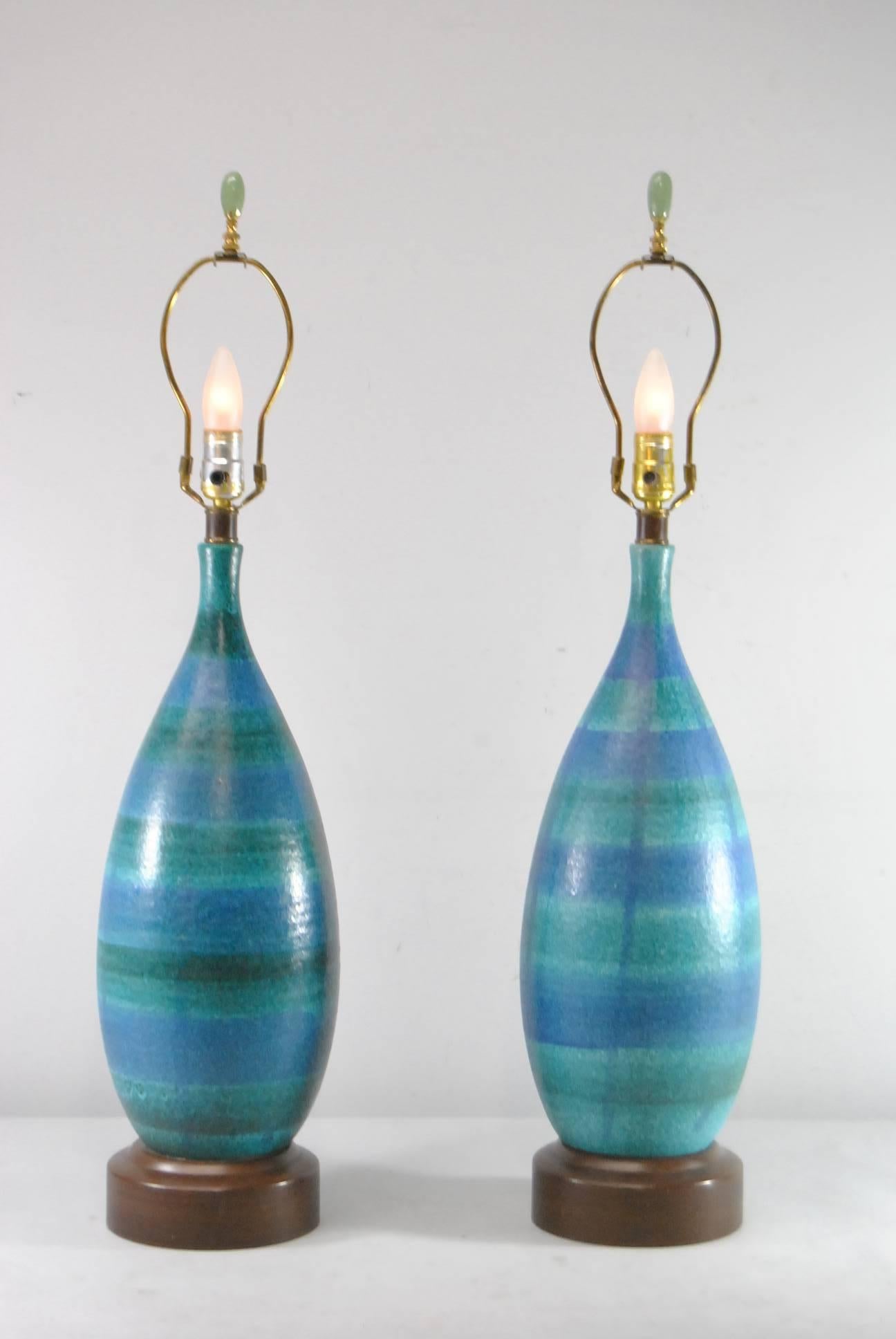 Pair of Bitossi for Raymor Pottery Vases mounted as table lamps. Decorated in blue and green glazes with jade finials. Very good condition with two firing glaze blemished that were in the making. Shades are not included. It is 34