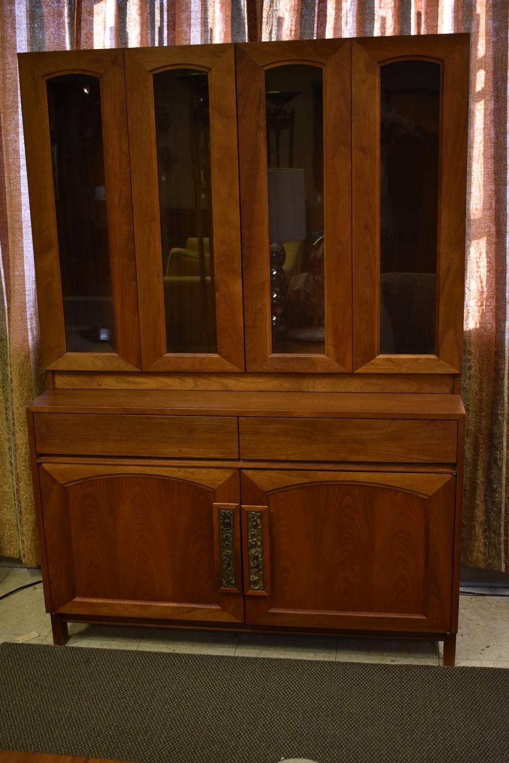 A great teak two-piece China cabinet designed by John Keal for Brown Saltman. The top piece has two bifold doors; each opens to a display area with two adjustable shelves. The top piece is 38