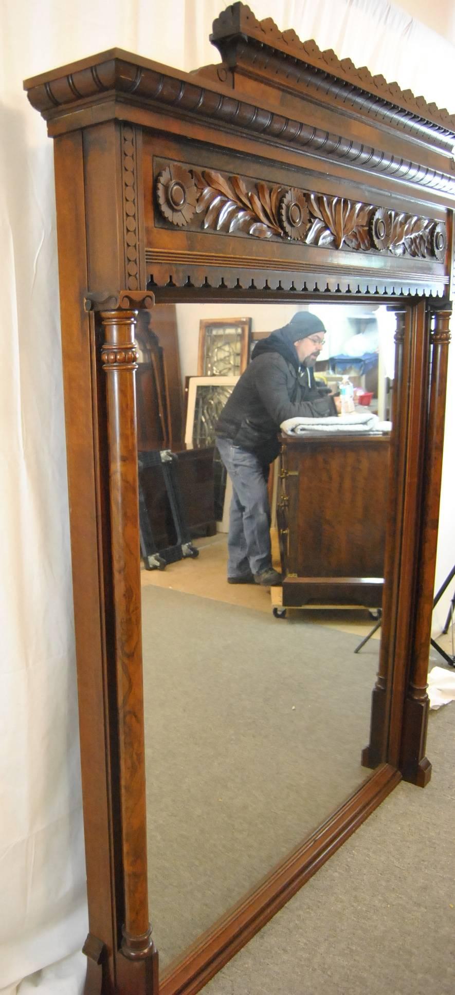 A beautiful walnut Victorian 81" tall walnut mantel mirror. The mirror has great high relief carved leafs and stylized flowers at the top of the frame inset within burl border. A burled wood crown plate is removable for a different look. Full