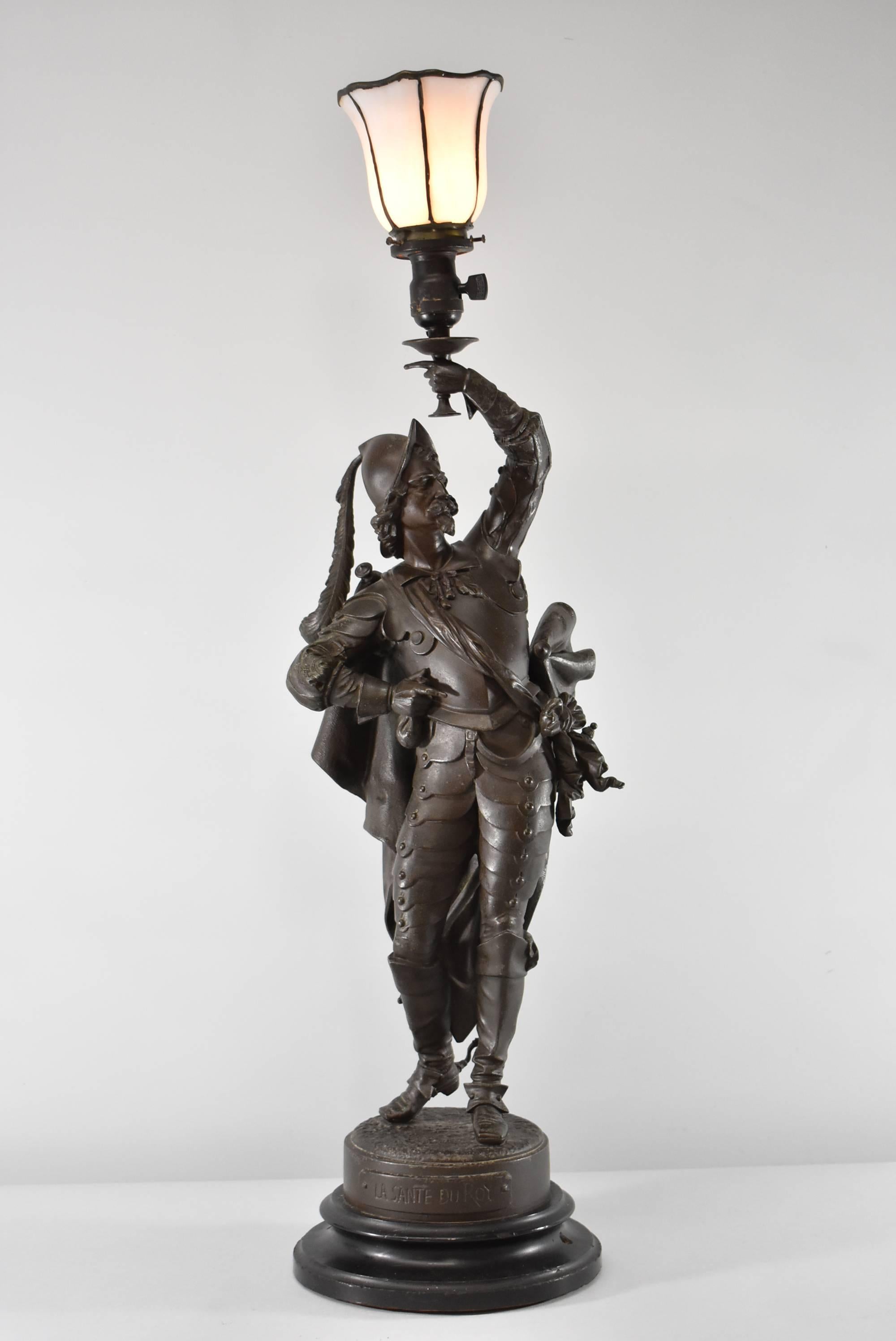 An exceptional antique newel post lamp by Philippe Poitevin, "La Sante Du Roy". A French artist that lived between 1831-1907. Artist signed on the base and features a french musketeer toasting to the 