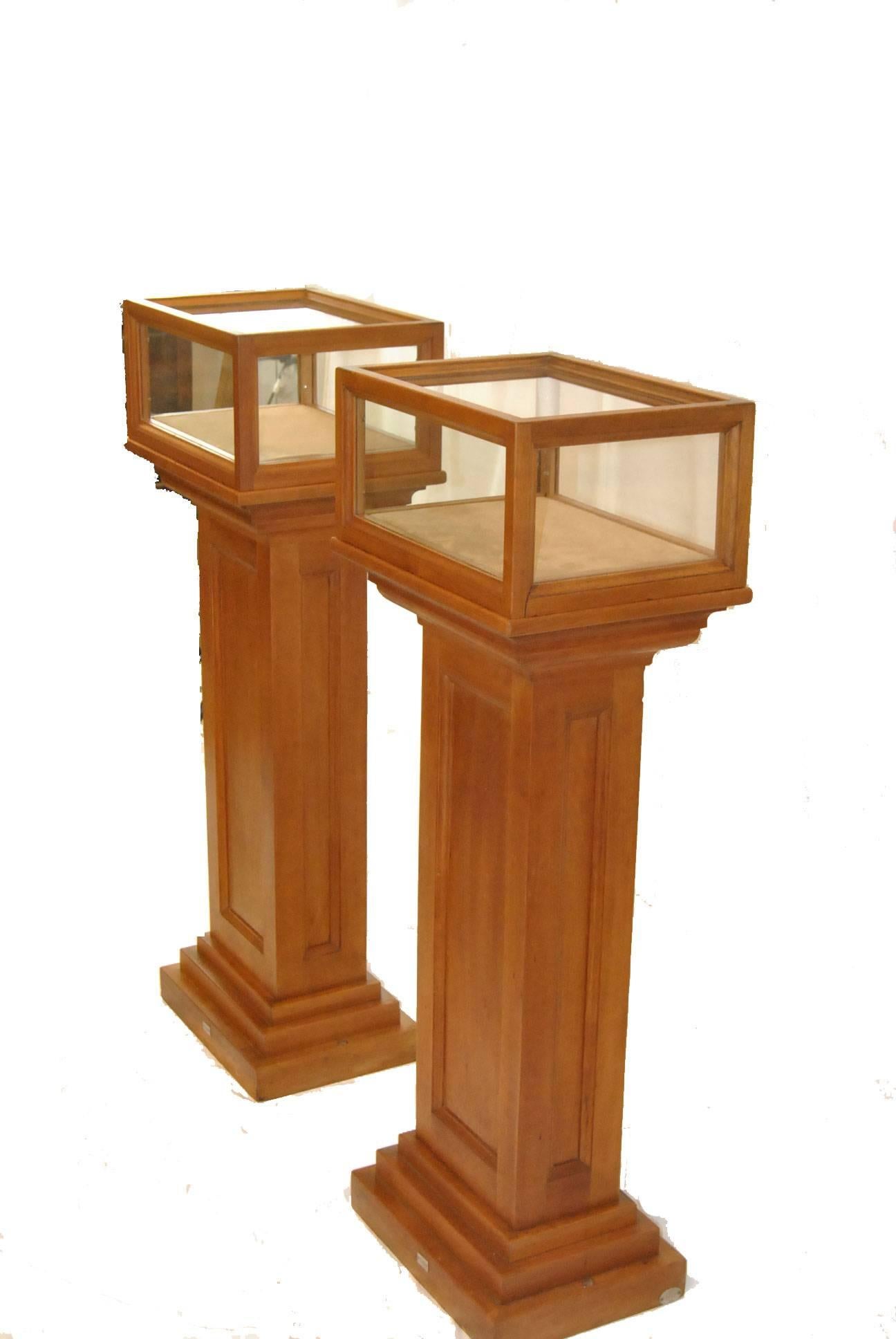 A very handsome pair of display pedestals, circa 1920s. This pair was decomissioned from the Toledo Museum of Art. Very heavy solid cheerywood with removable top glass boxes that can be screwed from the bottom to secure to the stands. There are