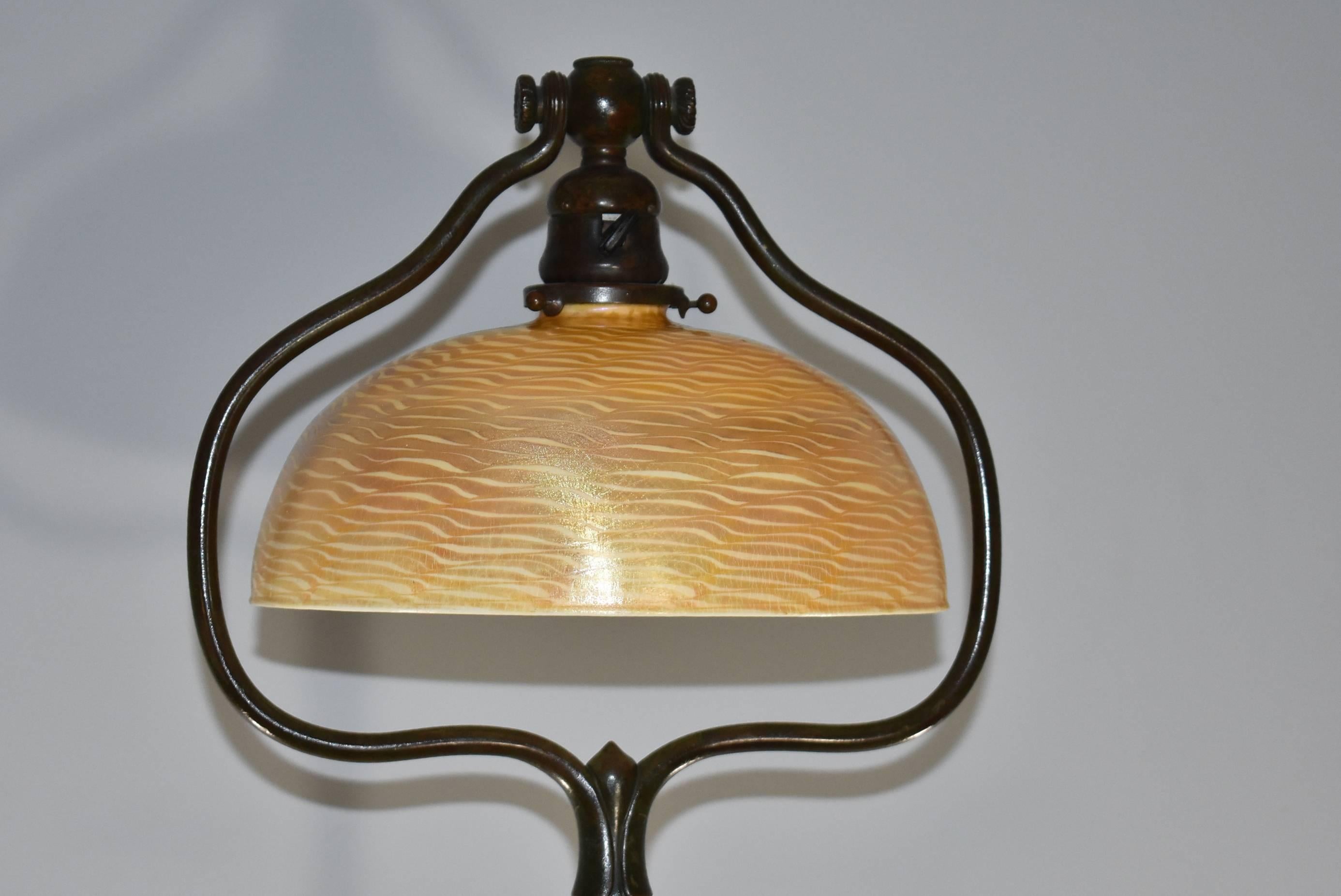 A Tiffany Studios floor lamp. It features a rich brown bronze original finish in very good condition and a gold Damascene Tiffany Favrile shade. Gold iridized highlights with a decorated damascene design. Signed on the shade L.C.T. Favrile. The base