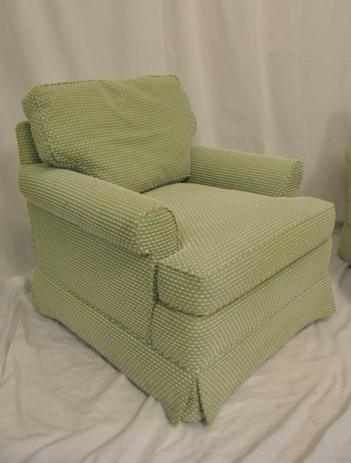 A beautiful pair of skirted occasional lounge chairs by Baker Furniture. The chairs are upholstered in a mint green with cream dash accents. (Color OAC121 from online auction color chart). Chairs have small rolled arms and are skirted with pleats at