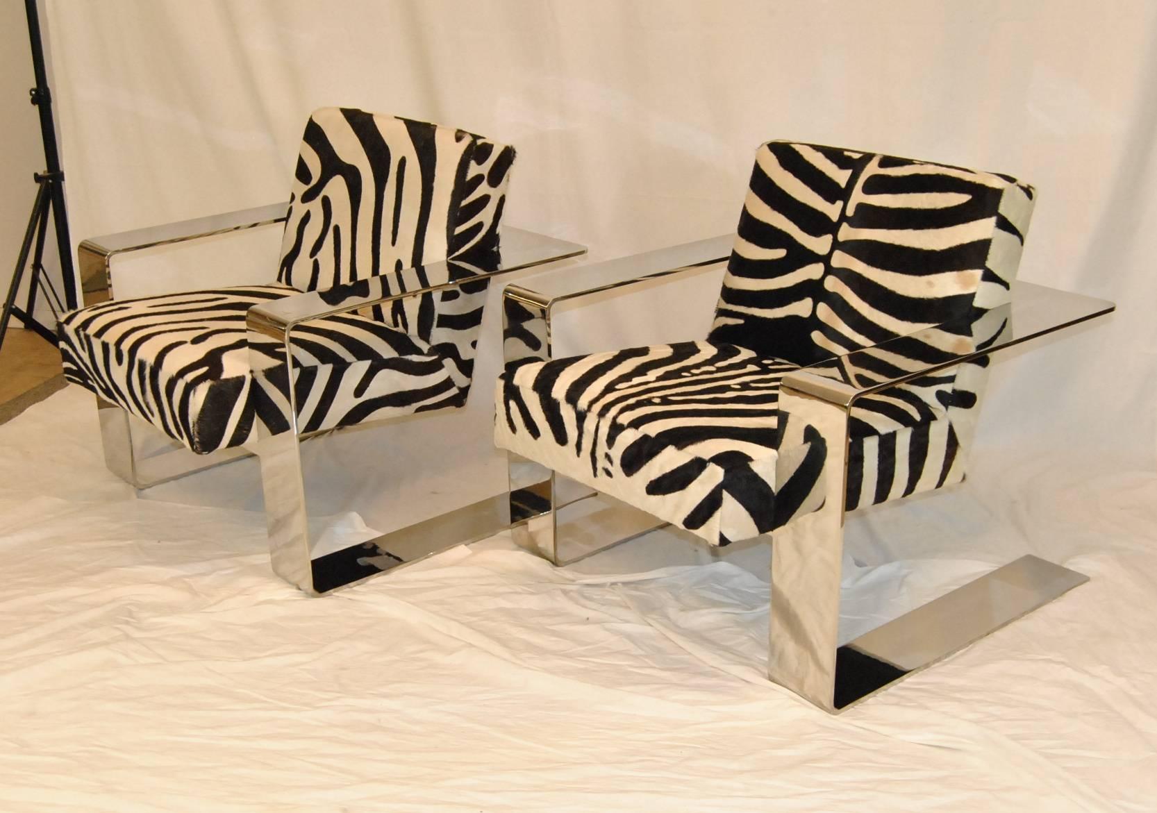 An electric pair of chrome framed Connor chairs by Bernhardt. The Connor chair is upholstered in a zebra printed cowhide that is soft to the touch and has a beautifully designed wide flat chrome base. The Connor chair can be a complement to anyone's