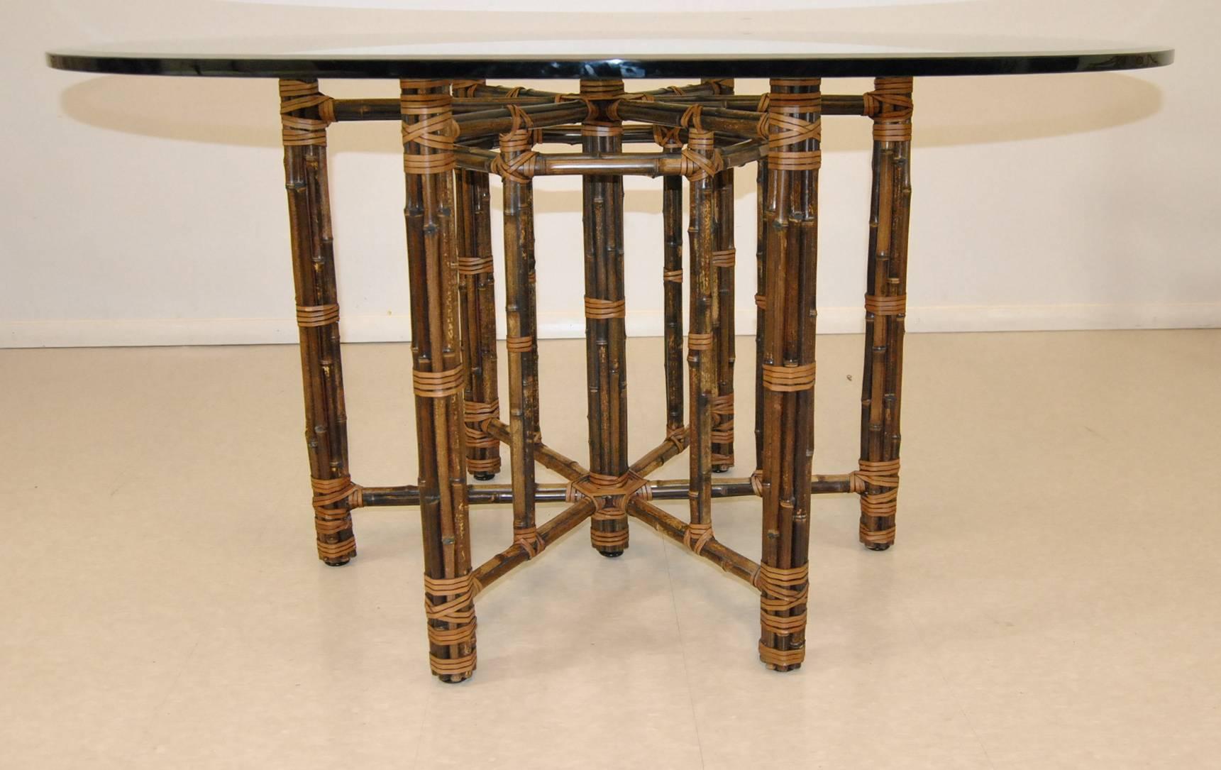 A beautiful glass top rattan dining table by McGuire. The bottom is a bamboo rattan base with lashings. The top is 54" diameter with a 1 inch beveled edge glass. This makes an excellent set with six target back chairs listed separately.