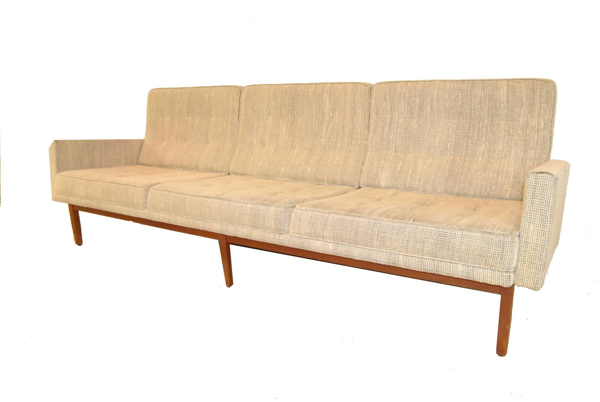 A Classic Mid-Century Knoll model 57W sofa. The floating frame has mortised and pinned construction and is very solid. Original upholstery is in a cream and grey woven fabric with tufted back and seat cushions. Unusual form makes this a highly