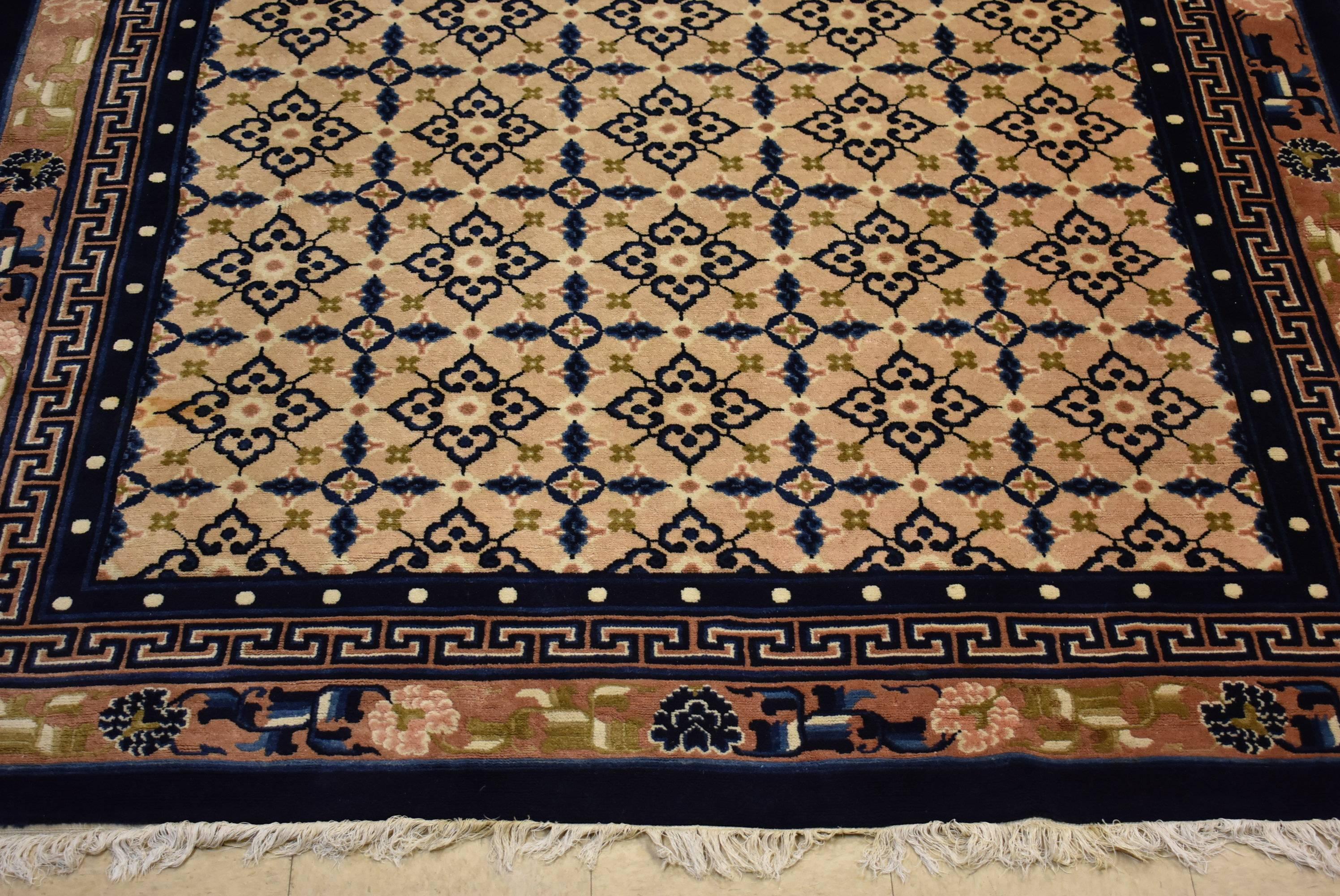 An exquisite Chinese Oriental rug. This beautiful rug was hand tied in shades of navy, cream, rose, green and black. Very good condition. There are a couple faint stains and the rights side is slightly darker. This has just been professionally