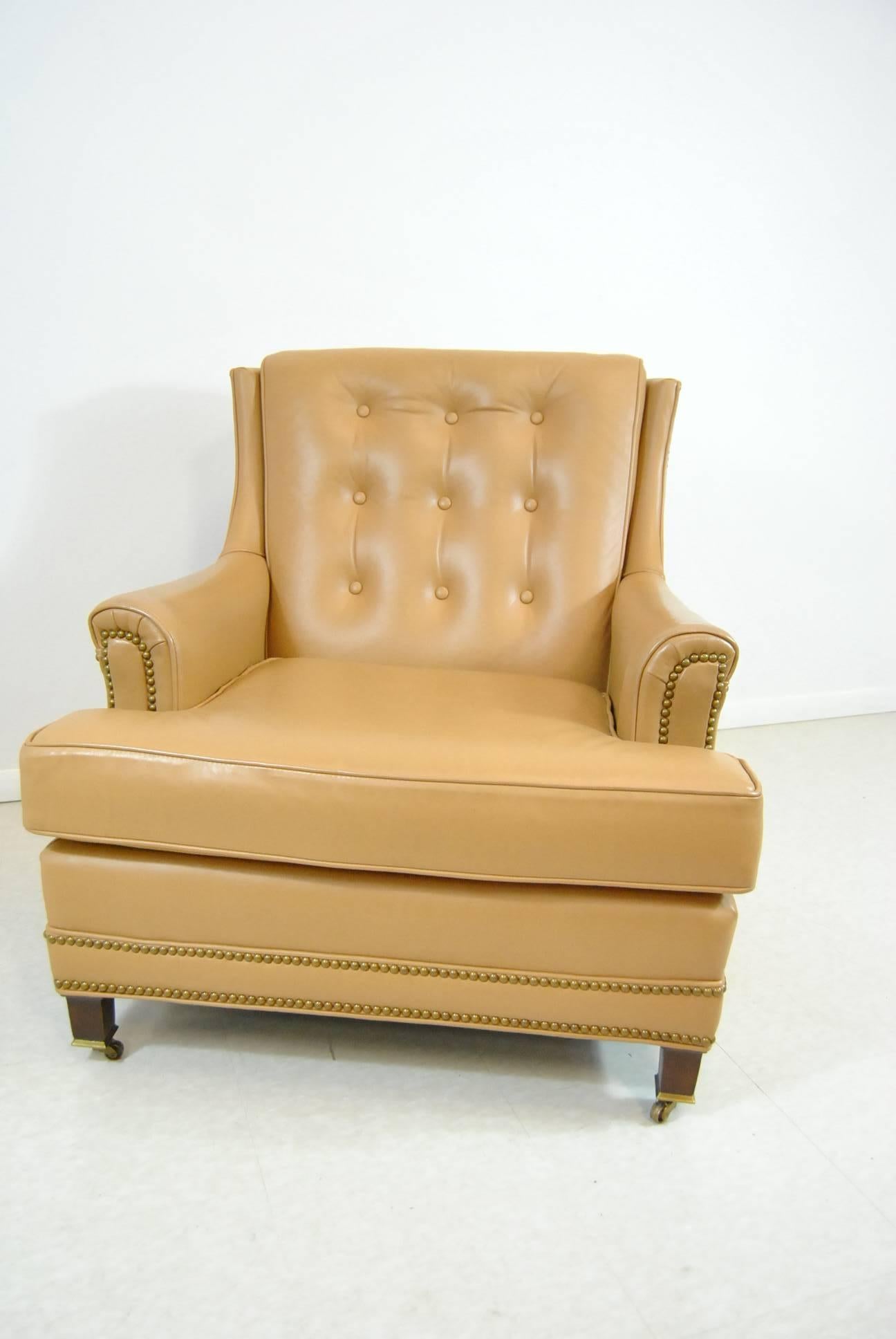 A stunning tan leather club chair and ottoman by Hanock and Moore. Nailhead trim and front casters add to the beauty of this set. This chair and ottoman set will provide you with a Classic and casual style for your home. Very good condition with