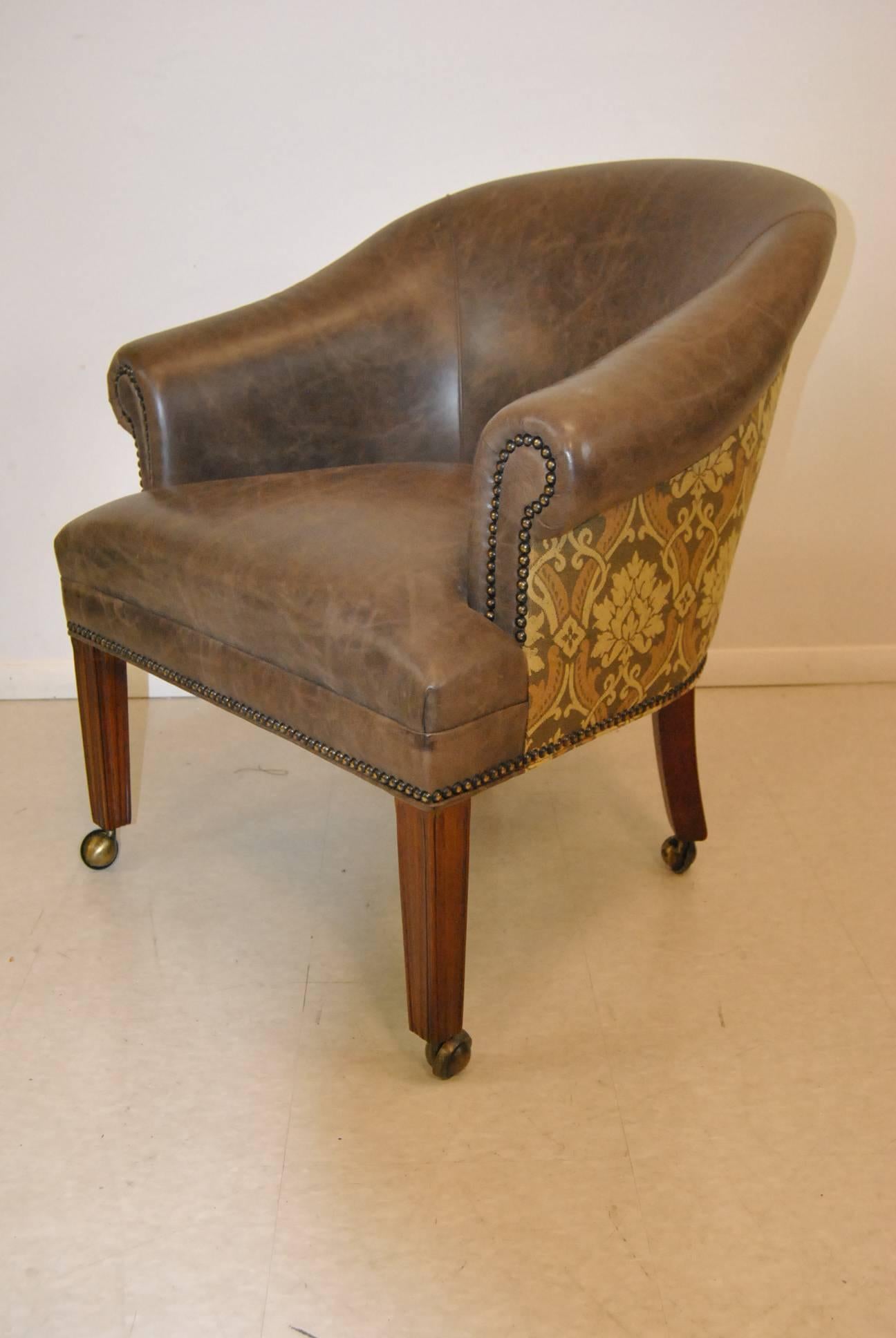 A beautiful set of four tub chairs by Hancock and Moore. These great chairs feature a factory distressed leather with a tapestry upholstery on the back and sides, nail head trim and castor legs. A very fine quality constructed set of chairs. The