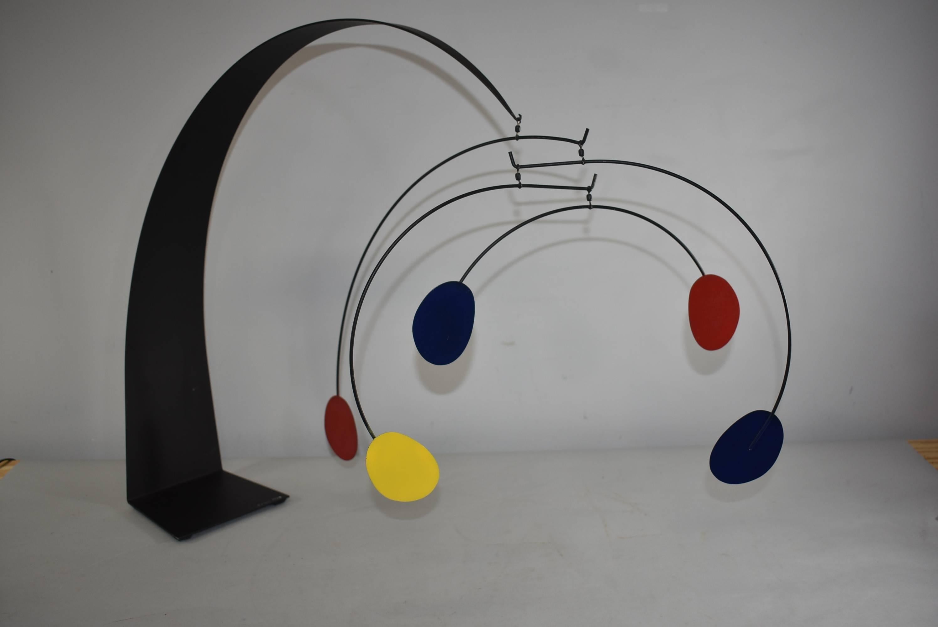 Great sculpture by Curtis Jere. It has a long black painted arm and base which arches gracefully. Four arms are suspended with disks of blue, red and yellow. An impressive size at 25