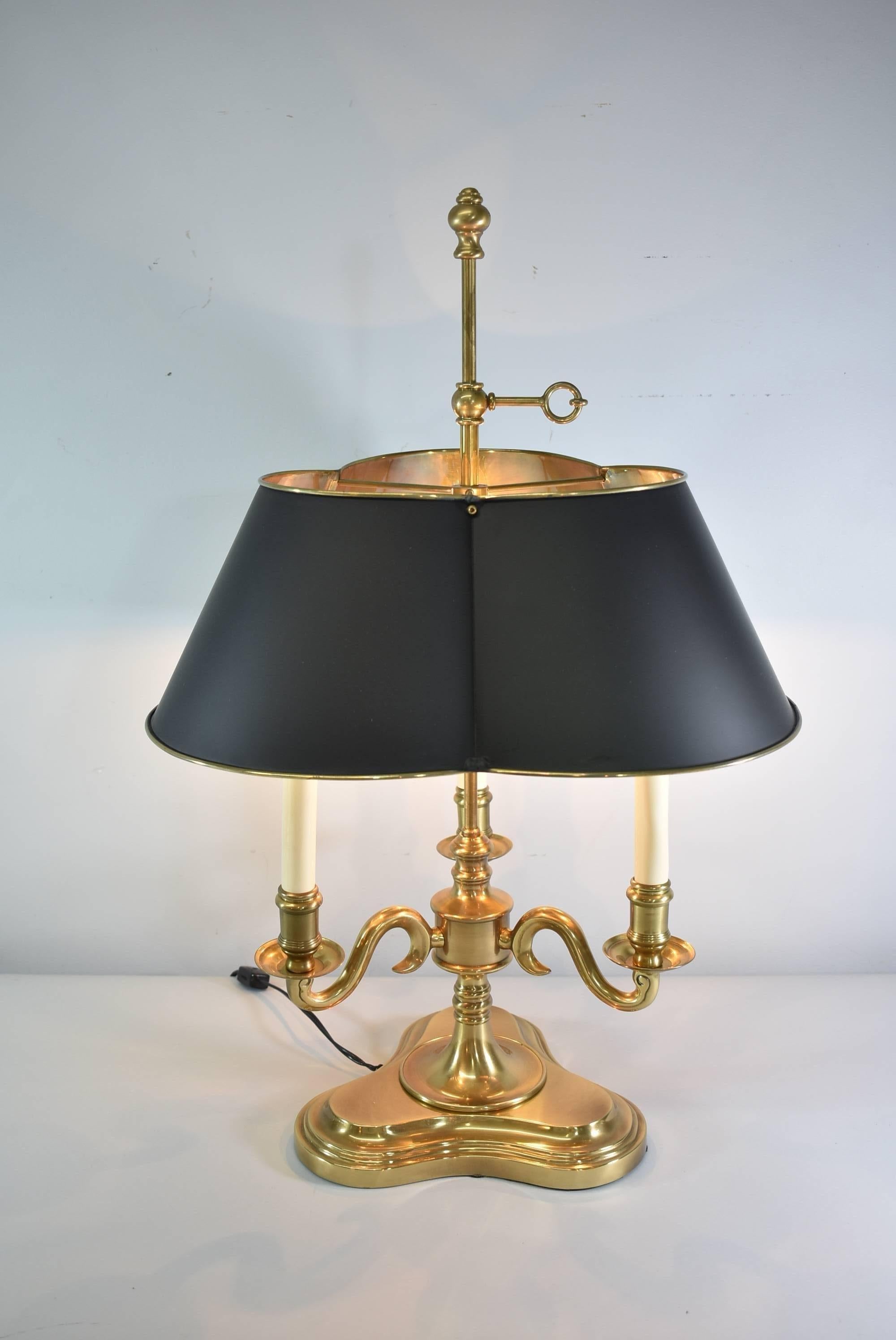 A beautiful brass Bouillotte lamp by Frederick Cooper. French Empire style with a painted black Tole shade and three candelabra style arms. Marked on the bottom with Frederick Cooper label. The lamp would look great in an office, den or large room.