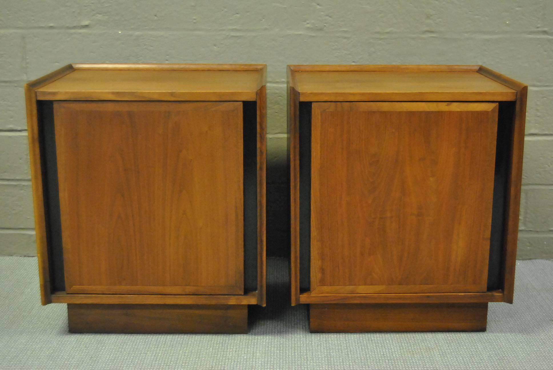 A great pair of walnut nightstands designed by Merton L. Gershun for Dillingham as part of their Esprit collection. Clean lines and great storage. Each stand has one white front drawer behind the door.