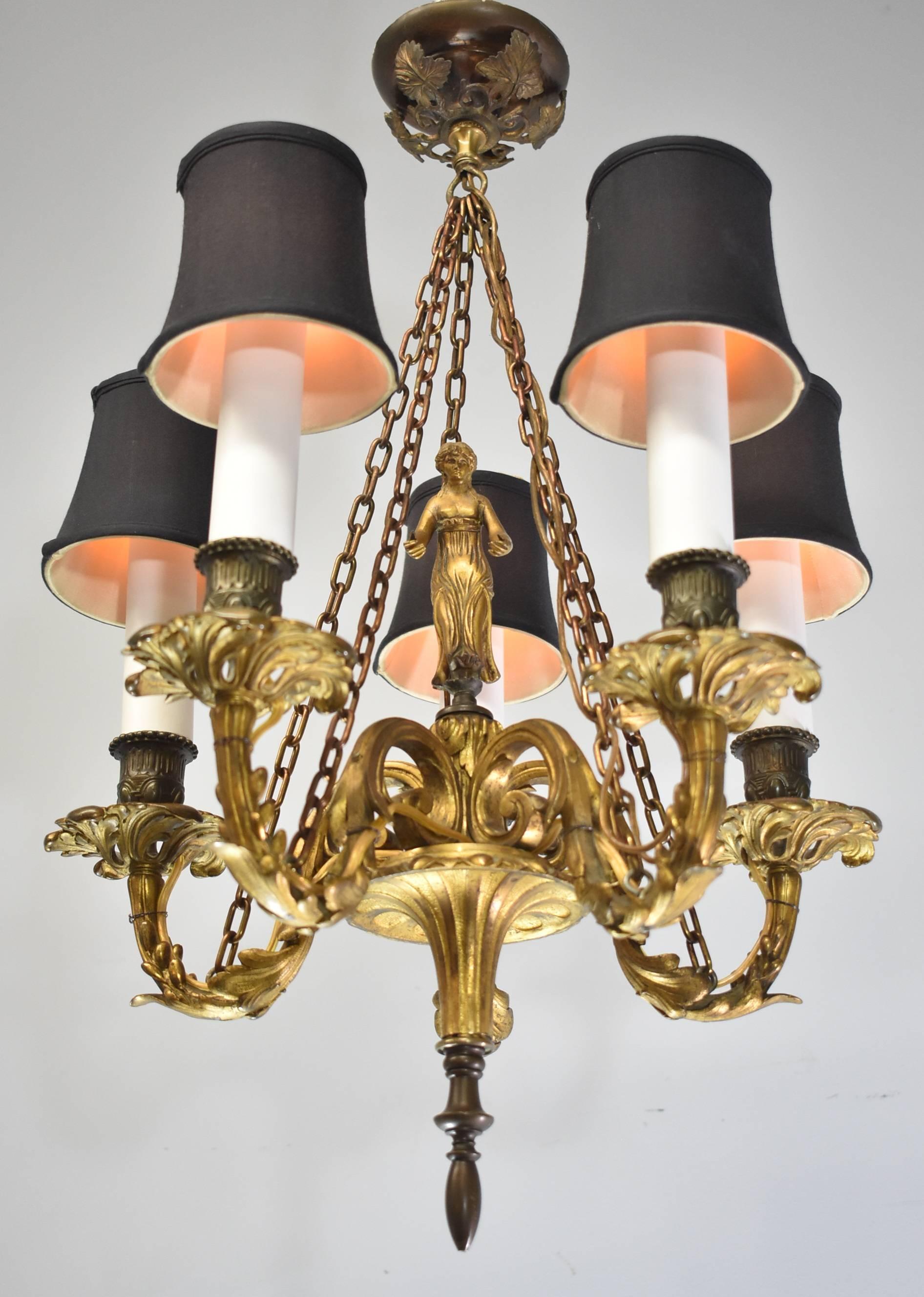 A stunning French bronze chandelier. This beautiful five-light fixture features a central female figure with flowing hair and gown, 5 arms with floriage detail and foliage detail adorns the ceiling cap as well. Very good condition with a nice
