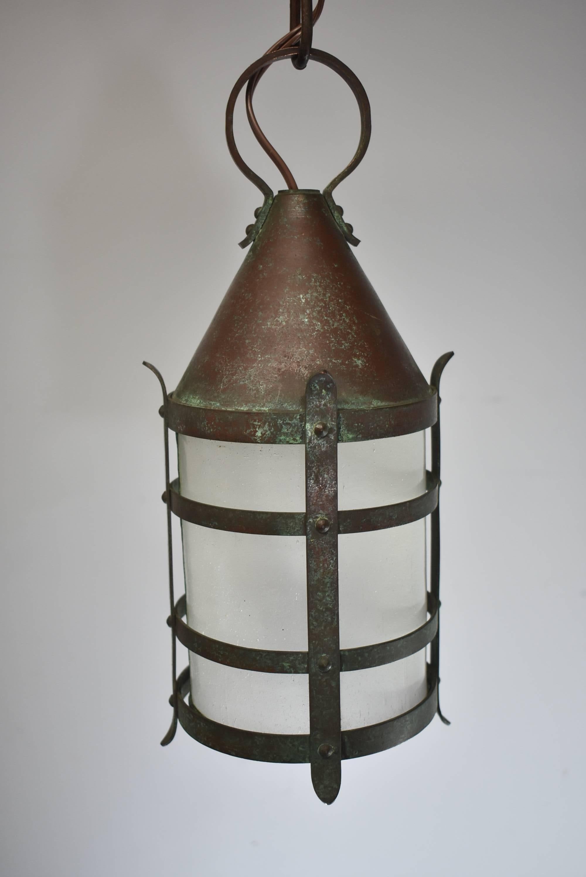 A great Arts & Crafts lantern style porch or hall entry light fixture. Frosted, bent pane, glue chip glass in copper casting with a conical cap. Signed Handel. It measures 21.5