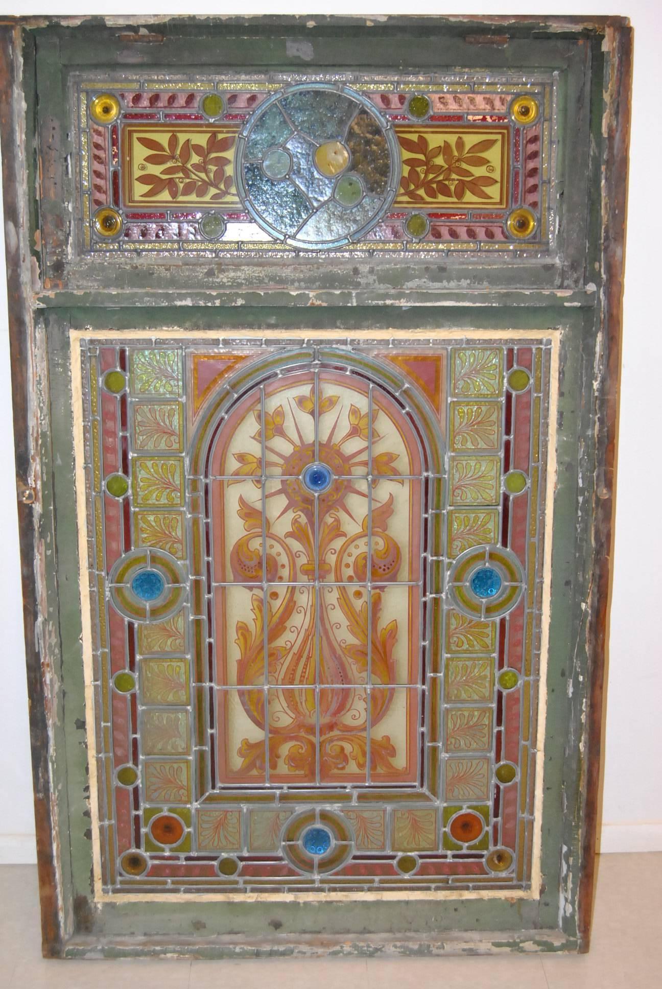 An absolutely stunning painted leaded glass landing window, circa 1880s.  It features a hand painted floral design with casted glass jewels.  It has the original frame and casement.  Great condition with no breaks.  This can also be removed from the