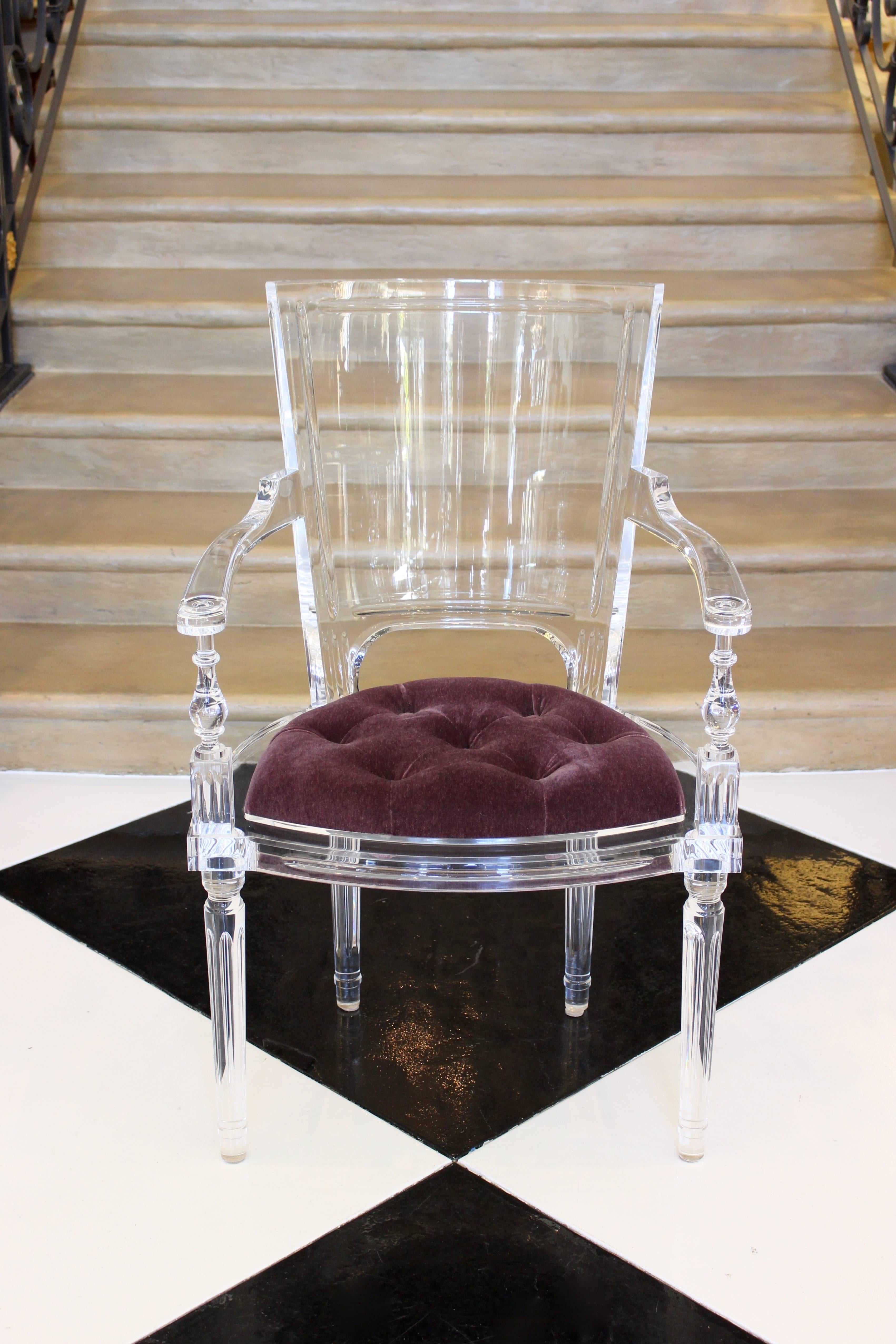 A contemporary Italian clear acrylic Marilyn cabriolet armchair in the Louis XVI style. This original armchair features a curved and lightly concave rectangular backrest with fluted details over a semicircular seat upholstered with a purple