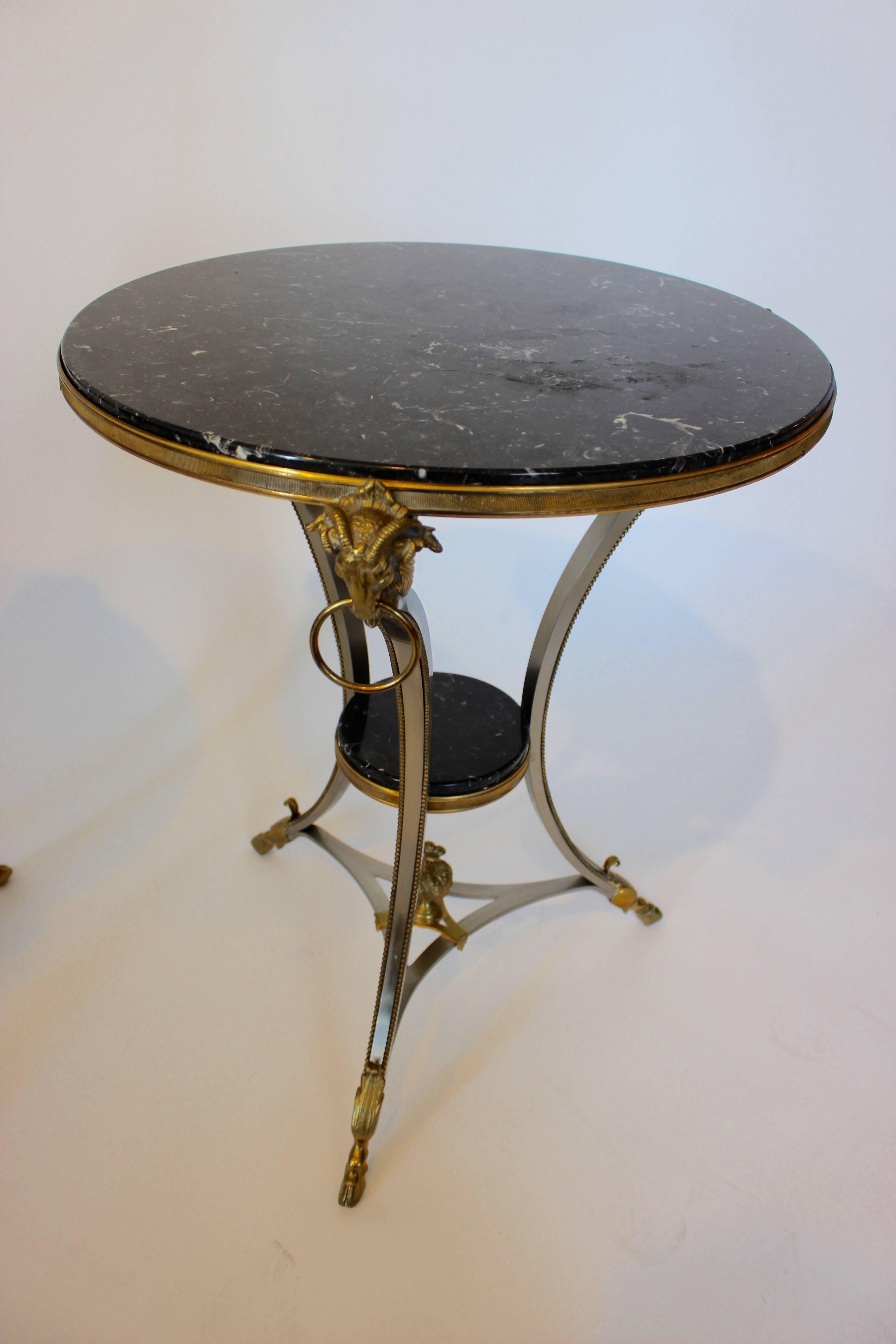 Américain Paire de tables Guridon en bronze doré et métal avec plateau en marbre noir et masques de béliers en vente