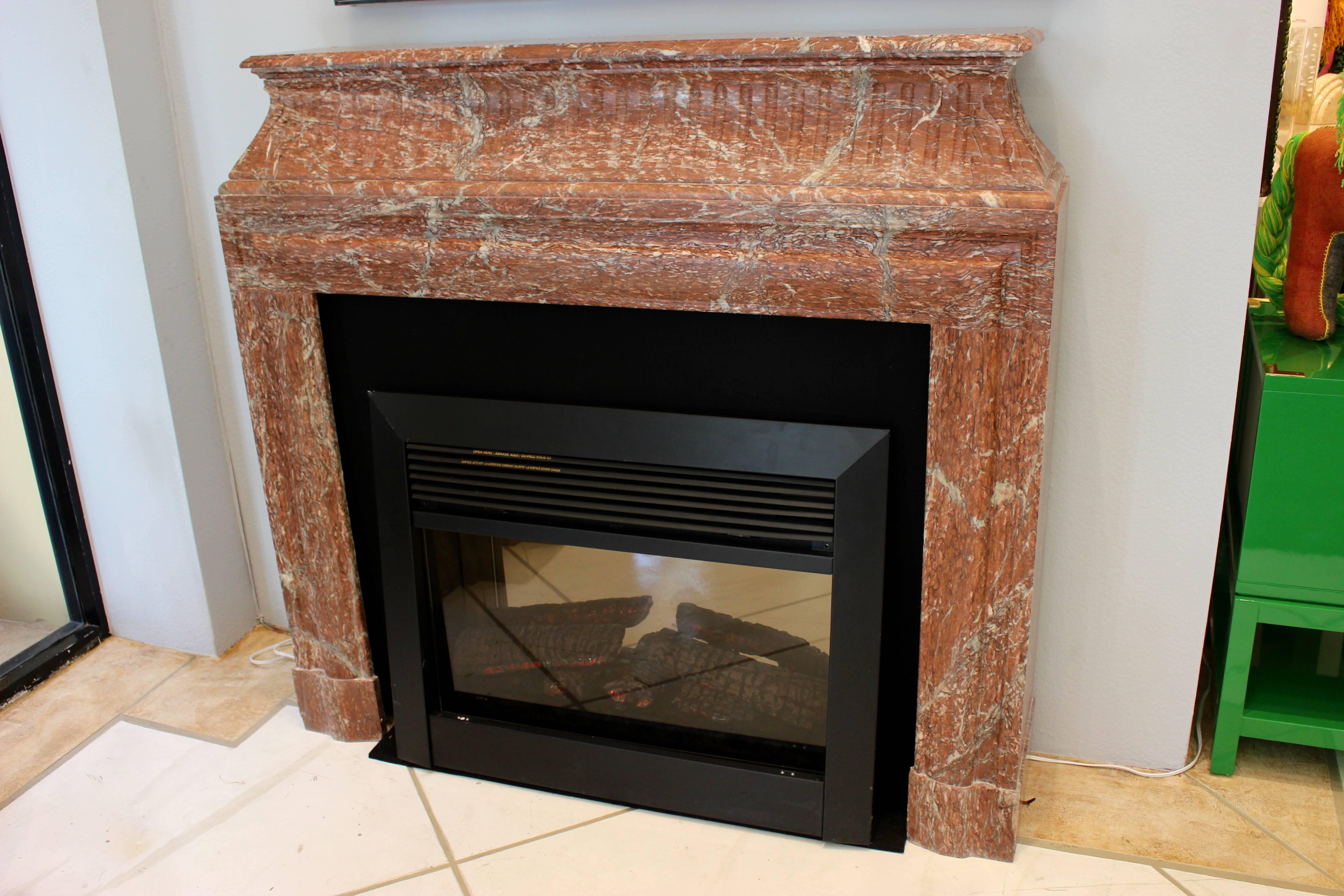 An elegant French rose marble fire mantel. The mantel sits upon a larger base with vertical cuts on sides and front, circa 1850.