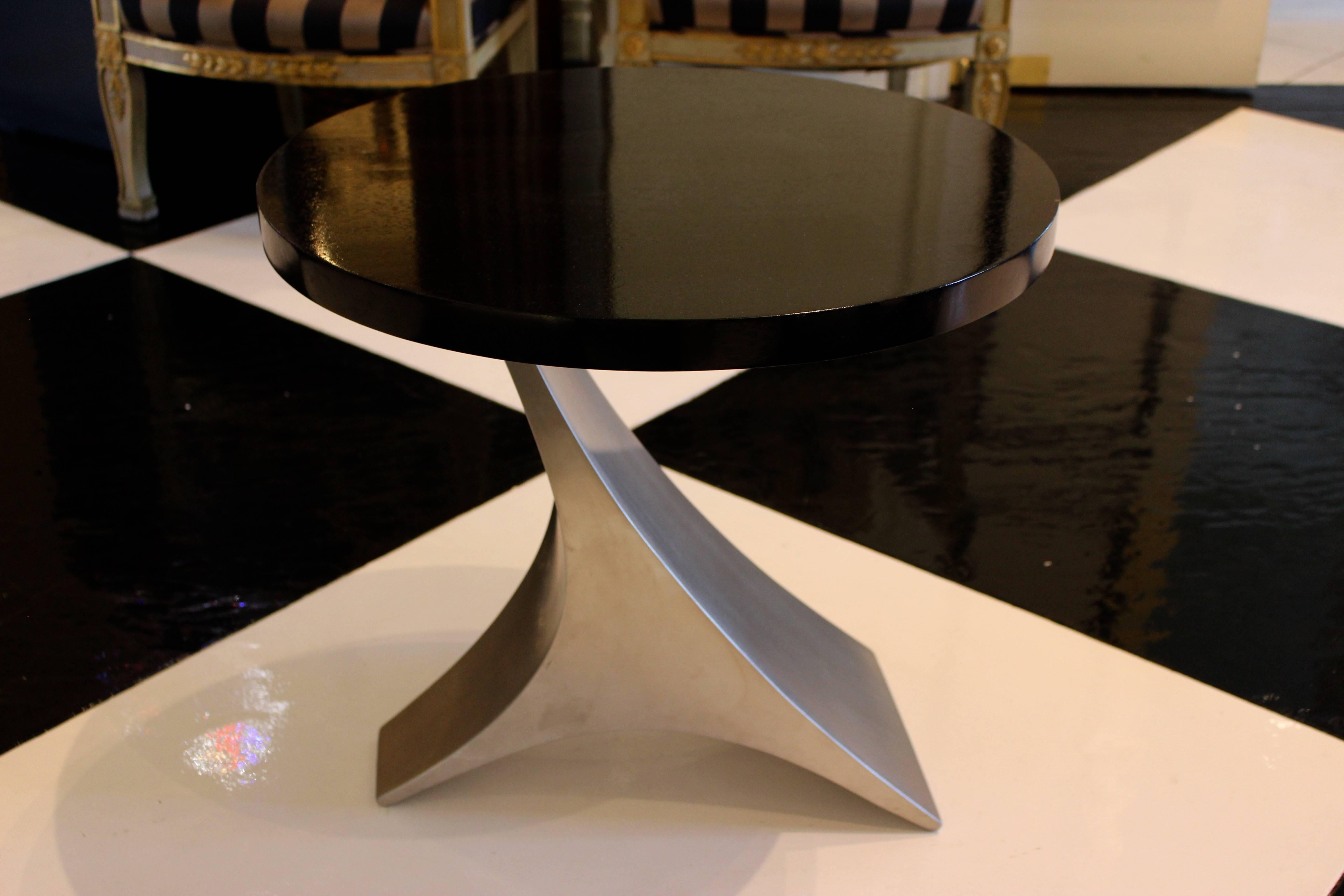 A small and stylish end table with dark brown top over curved chrome base.