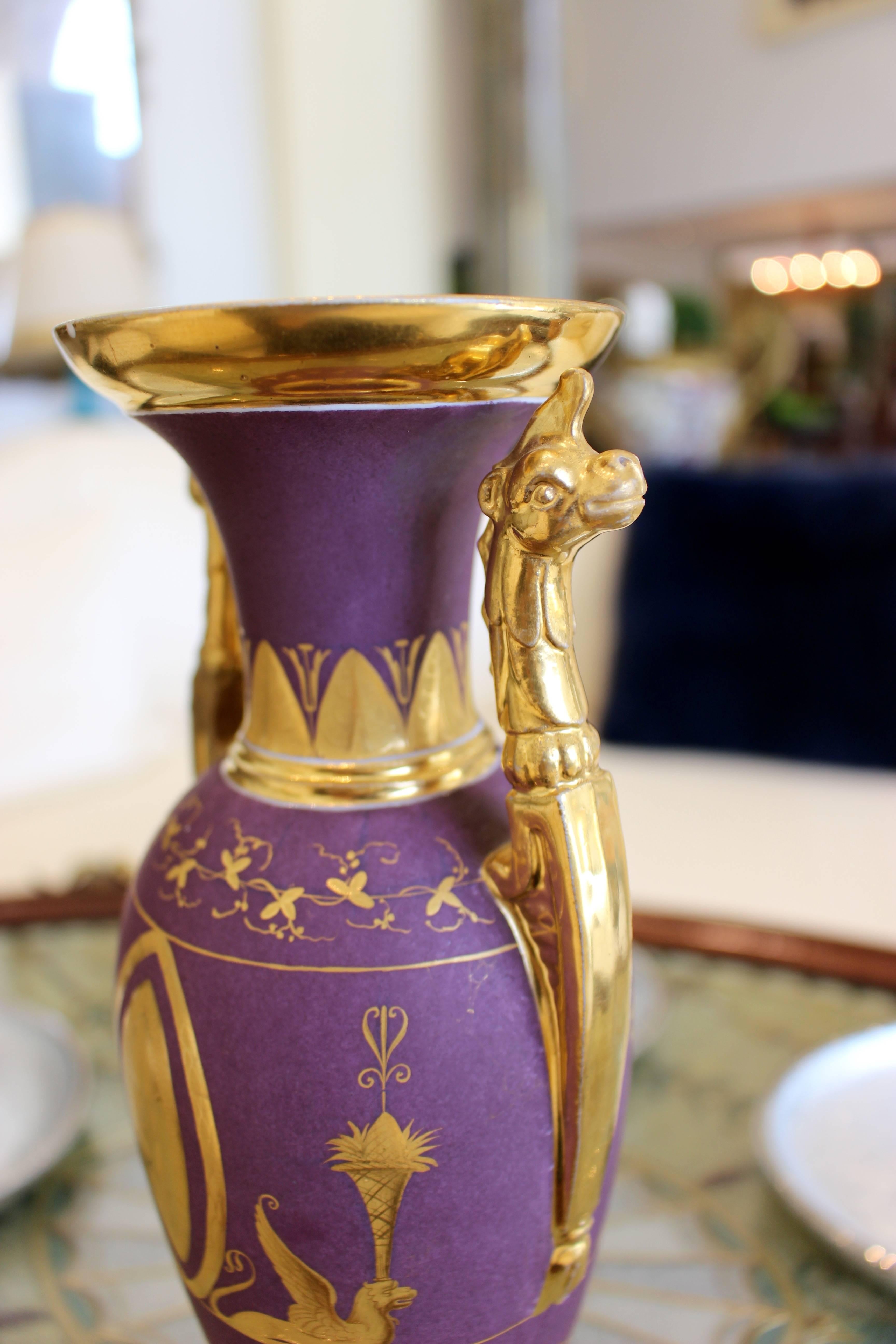 A Paris porcelain matte-purple and gold ground vase. Oviform with upright dragonhead handles, gilt with a terrace of griffins flanking lozenges, circa 1810.