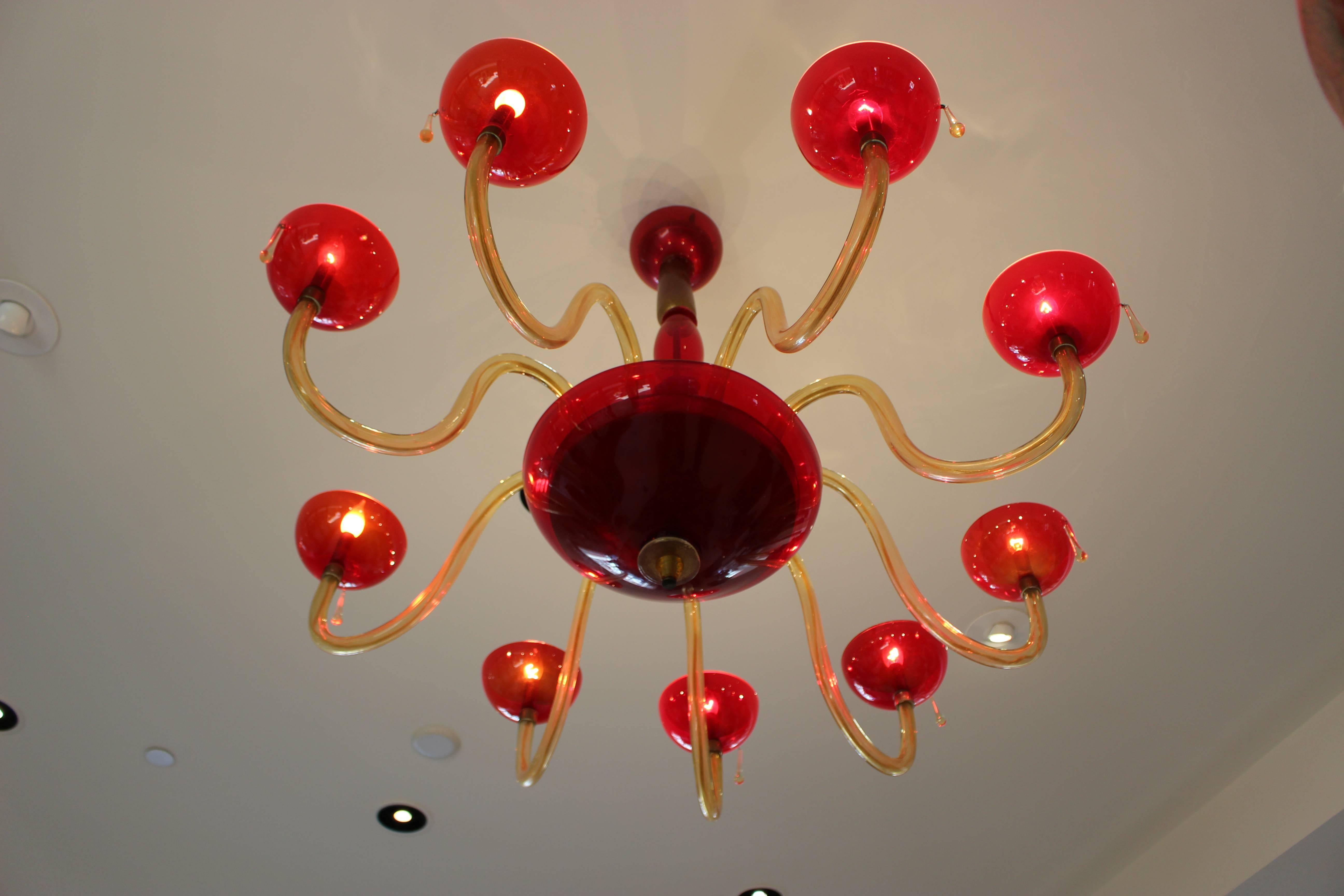 Un lustre italien vintage de Murano à neuf lumières en rubis, or et incolore, datant de la seconde moitié du 20e siècle. Ce gracieux lustre italien de Murano fabriqué à la main est composé de luxueux verres rubis, dorés et incolores et présente une