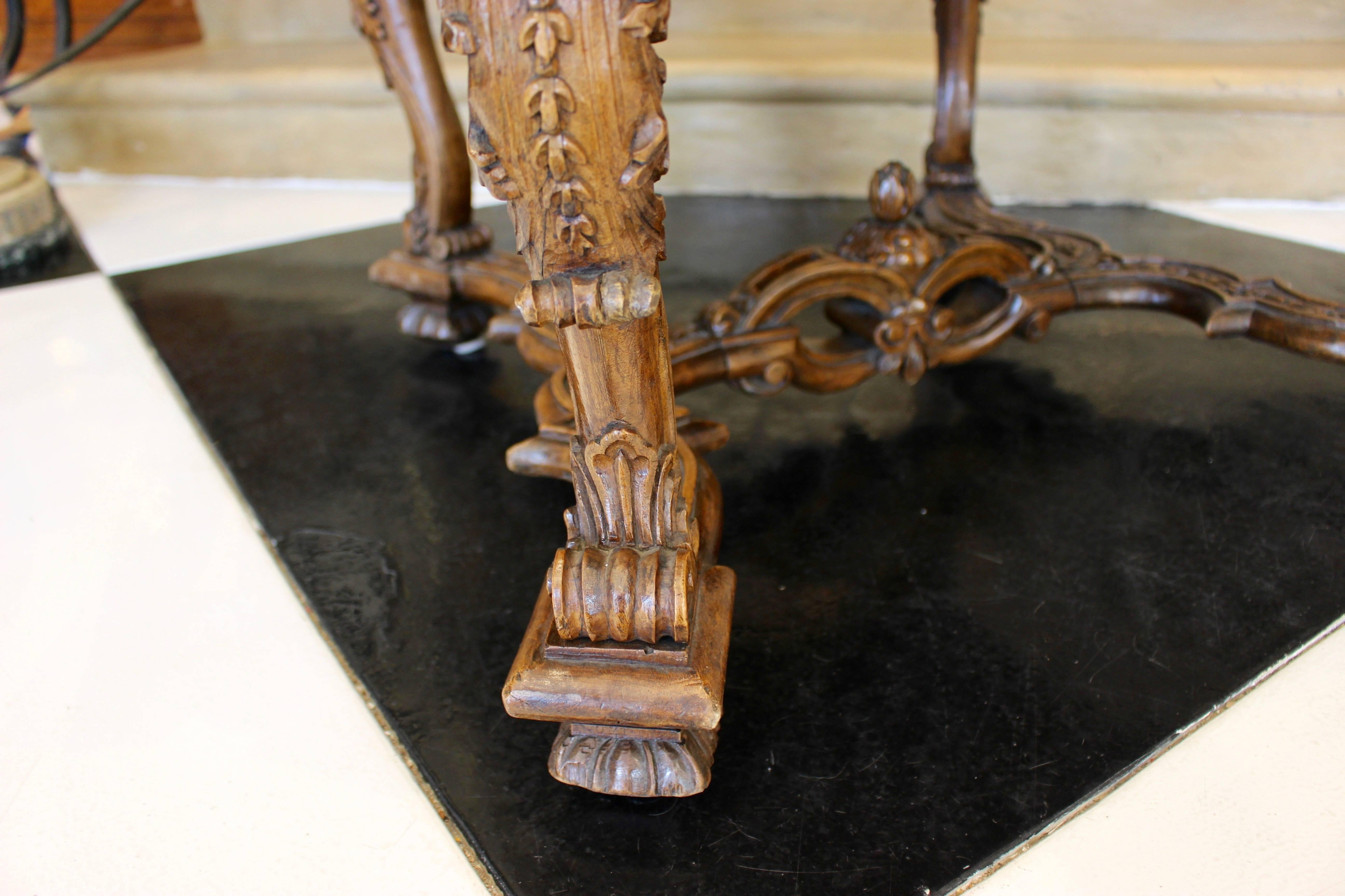 Ein geschnitzter Kamelrückensessel aus Nussbaum im Barockstil aus der Mitte des 19. Jahrhunderts mit geschwungenen Armen und Beinen, Querstrebe und neuer Polsterung. Dieser Fauteuil im Barockstil hat eine leicht abgeschrägte Kamelrückenlehne, aus
