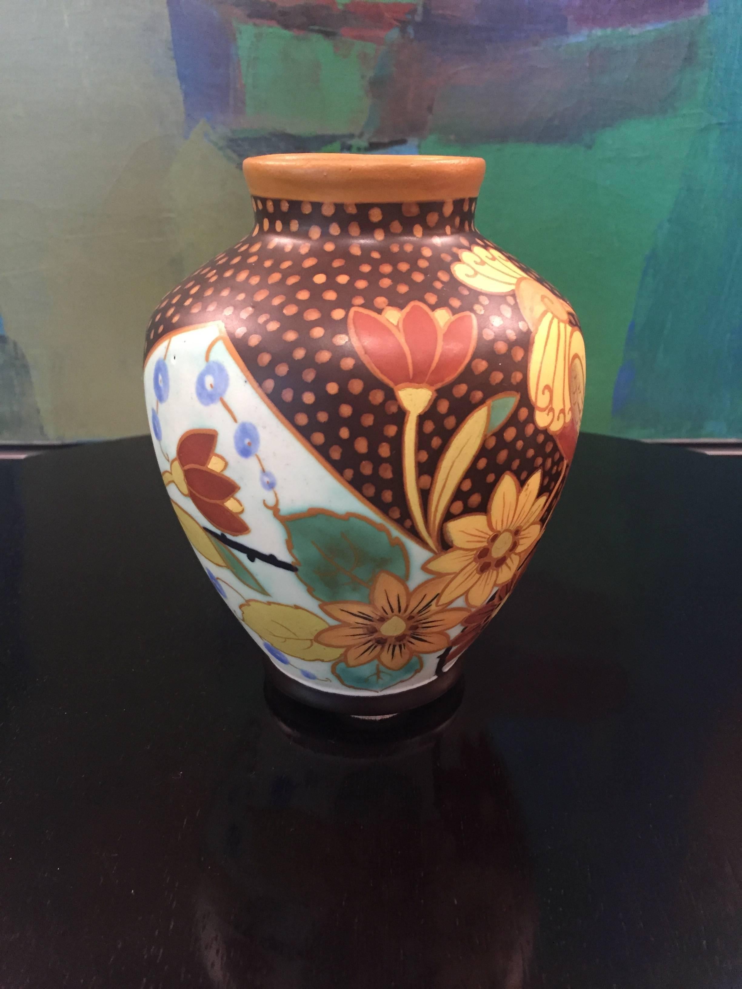 An Art Deco ovoidal vase in polychrome matte enameled earthenware with rounded shoulder and everted neck from the Belgian Boch Frères Keramis Factory. The tropical decor covering the body features a stylized crested parrot amongst blossoming