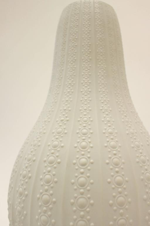 A south German matte white porcelain floor vase decorated in relief from Heinrich and Co. This sophisticated gourd-shaped vase presents raised geometric motifs of circular dots, shrinking towards the rim and separated by delicate vertical ribs,