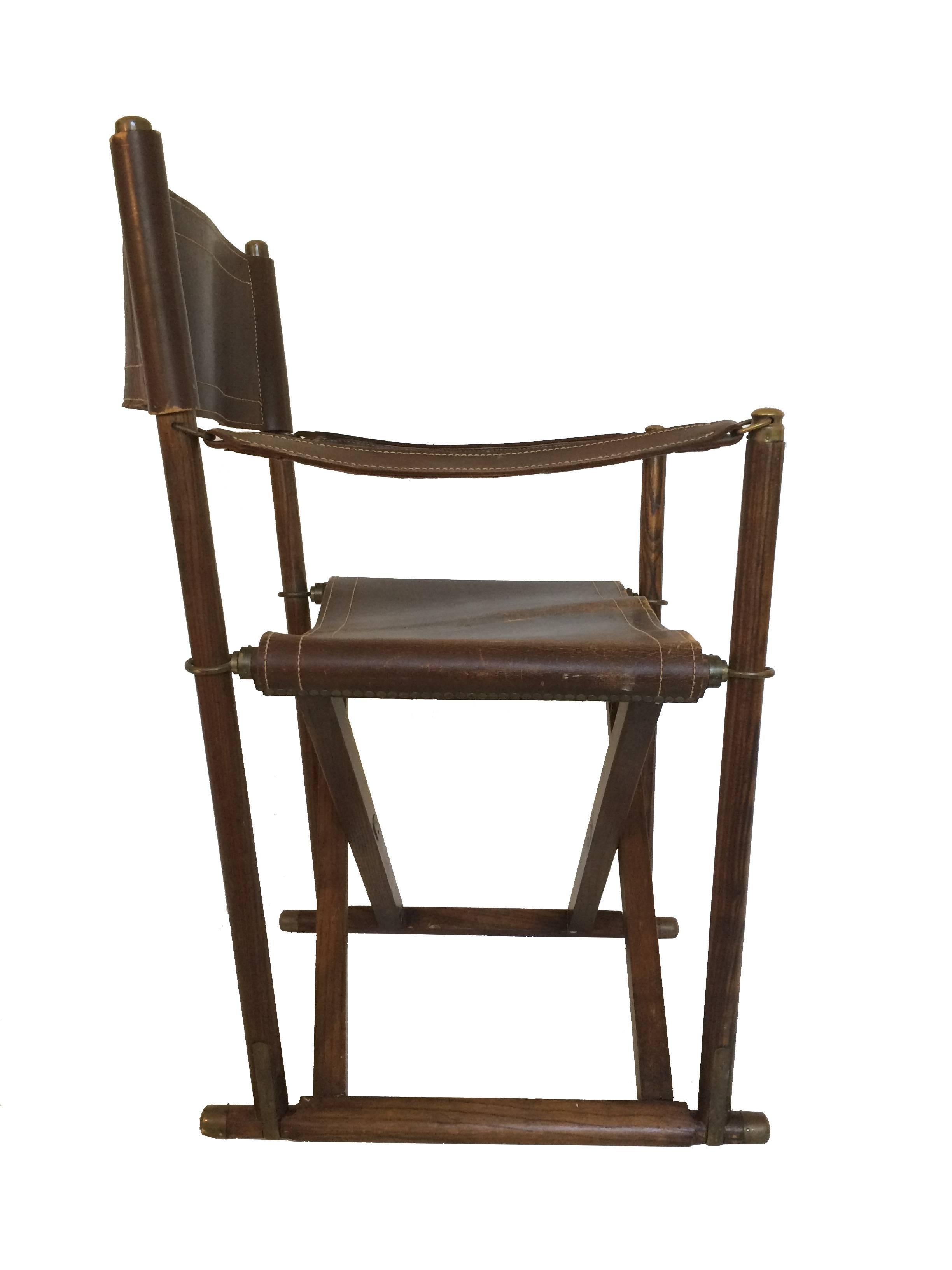 A foldable safari chair by Danish architect and designer Mogens Koch. Designed in 1932 the MK-16 is made of a stained frame with leather seating, backrest and armrests and is accented by brass hardware which indicate an early production period.