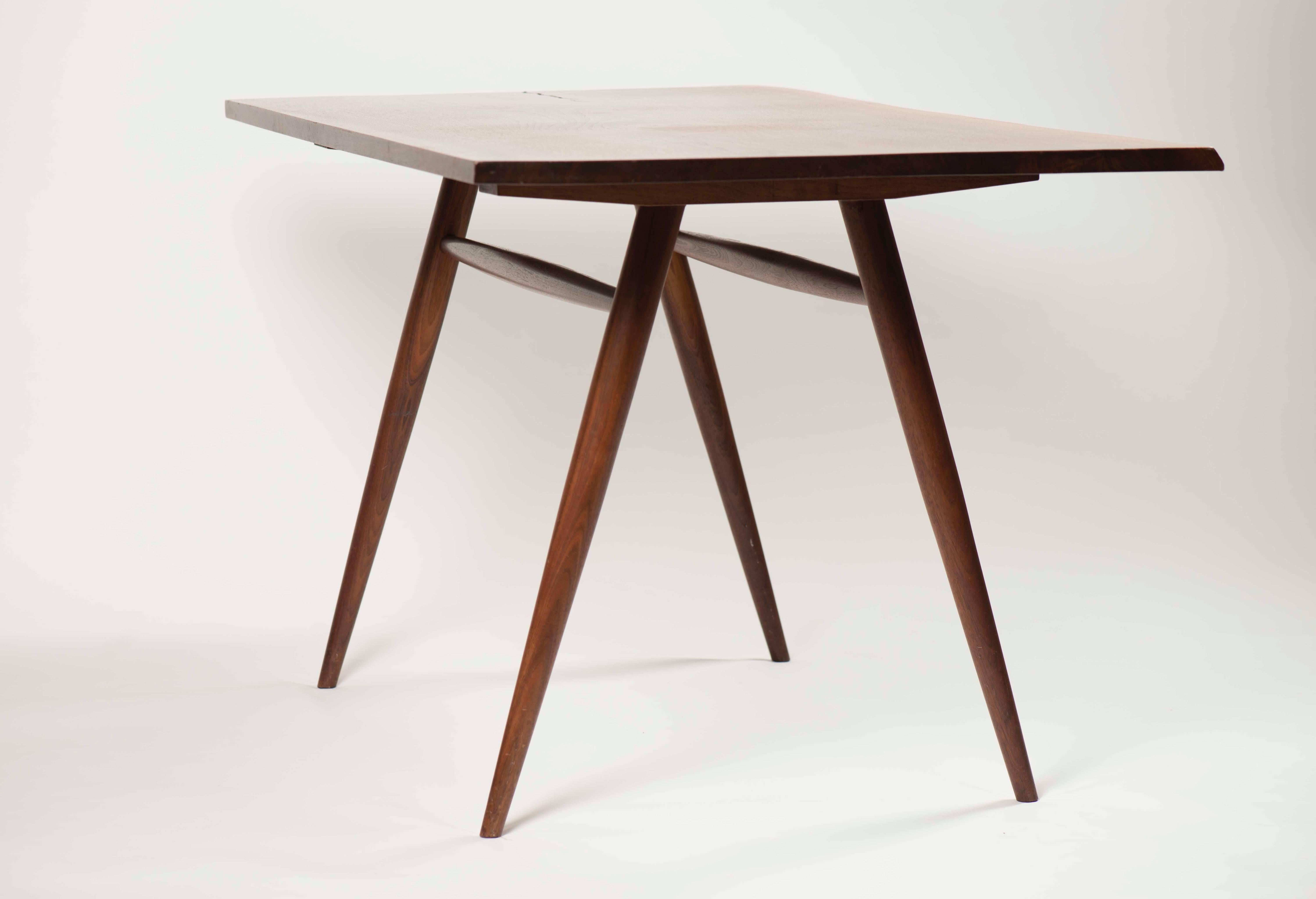 A beautiful, sculptural example by renowned woodworker George Nakashima. Tapered legs, live edge and butterfly key inlays showcase the signature attributes of Nakashima's work. The size makes the table ideal for smaller dining areas or suitable as a