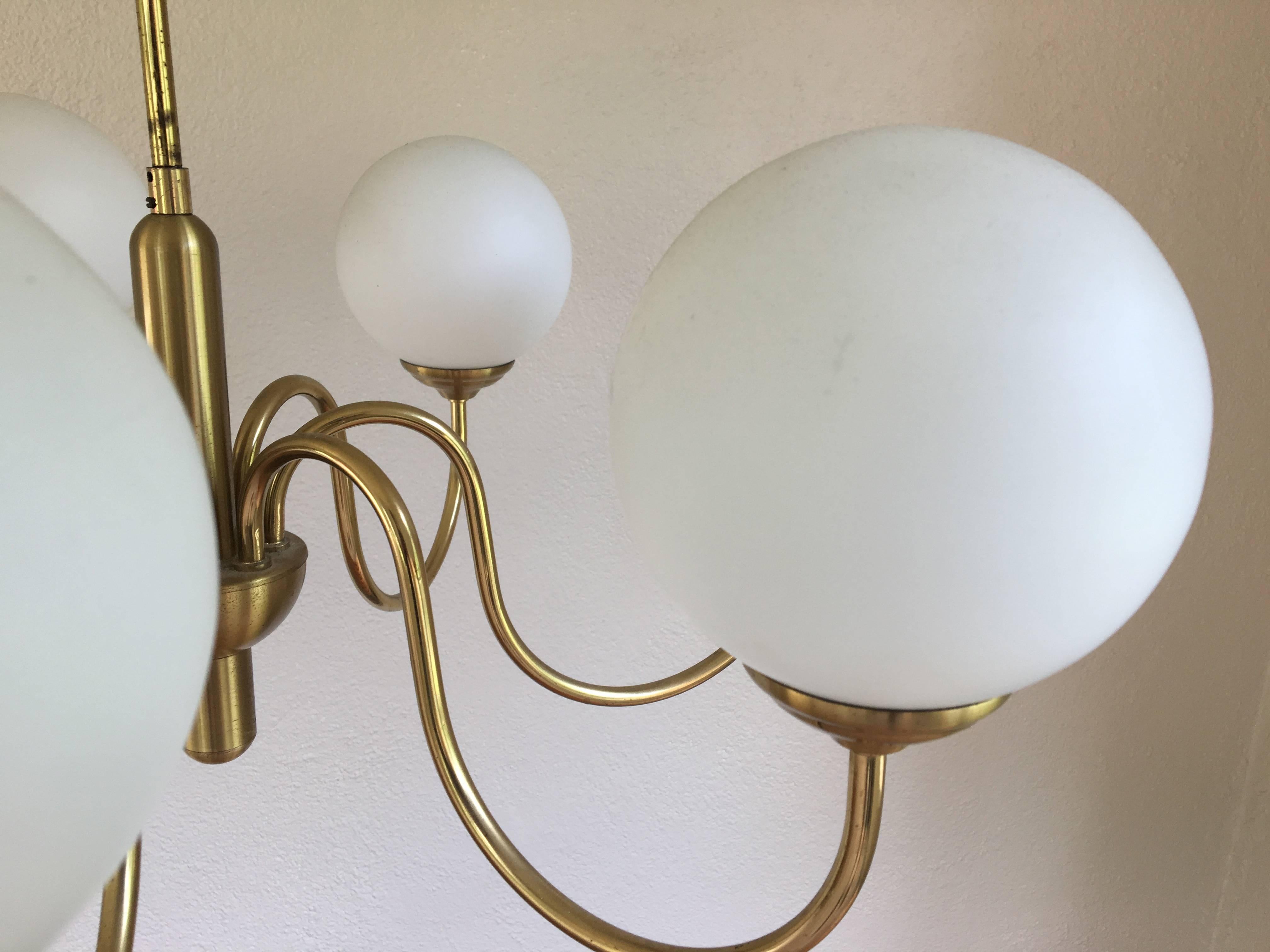 Beautiful seven-arm brass chandelier in the style of Angelo Lelli, Gino Sarfatti Arredoluce or Hans Bergström. Very heavy, solid construction. The brass has not been cleaned leaving the buyer to decide the patina.
