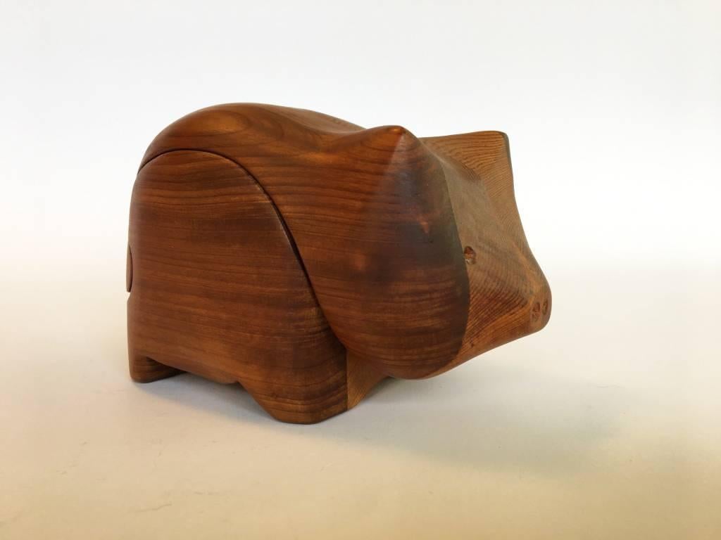 Very small pig jewelry box by Deborah Bump. Wooden puzzle piece construction allowing the box to slide open. Stamped.