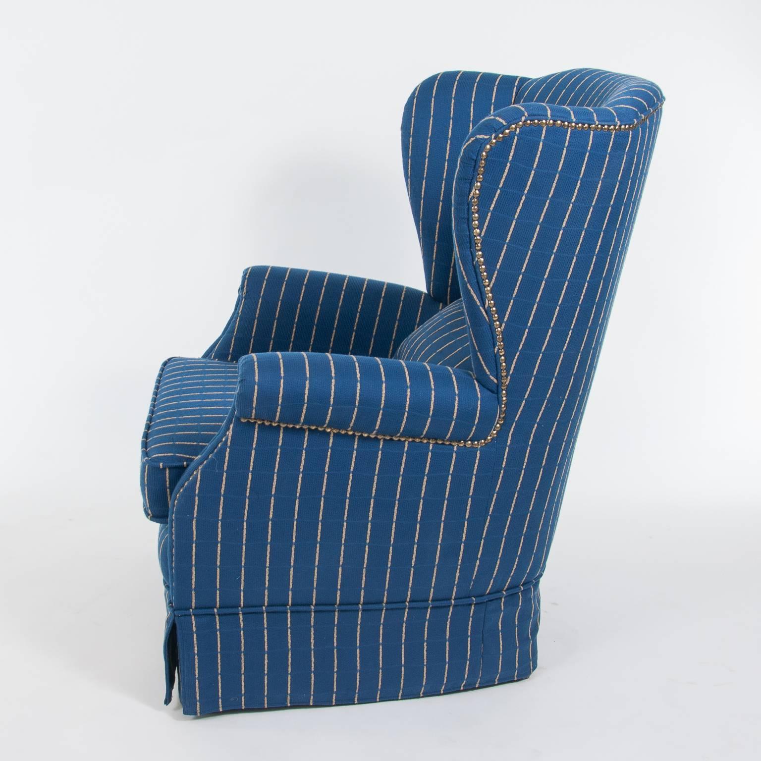 Tufted wingback chair with ottoman. A high-quality blue skirted upholstery from the well-known Austrian Company Backhausen with accented piping.
The ultimate in luxury and comfort. Great for bedroom or dressing room.

The chair and the ottoman are
