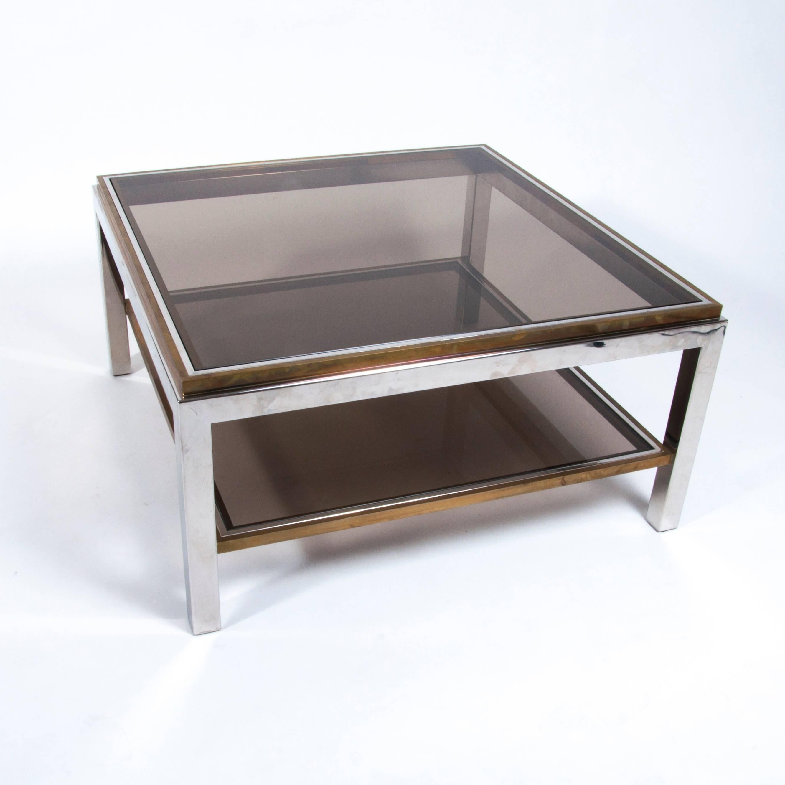 Small two-tiered coffee table designed by Willy Rizzo. 
The combination of chrome, brass and smoked glass is very stylish.