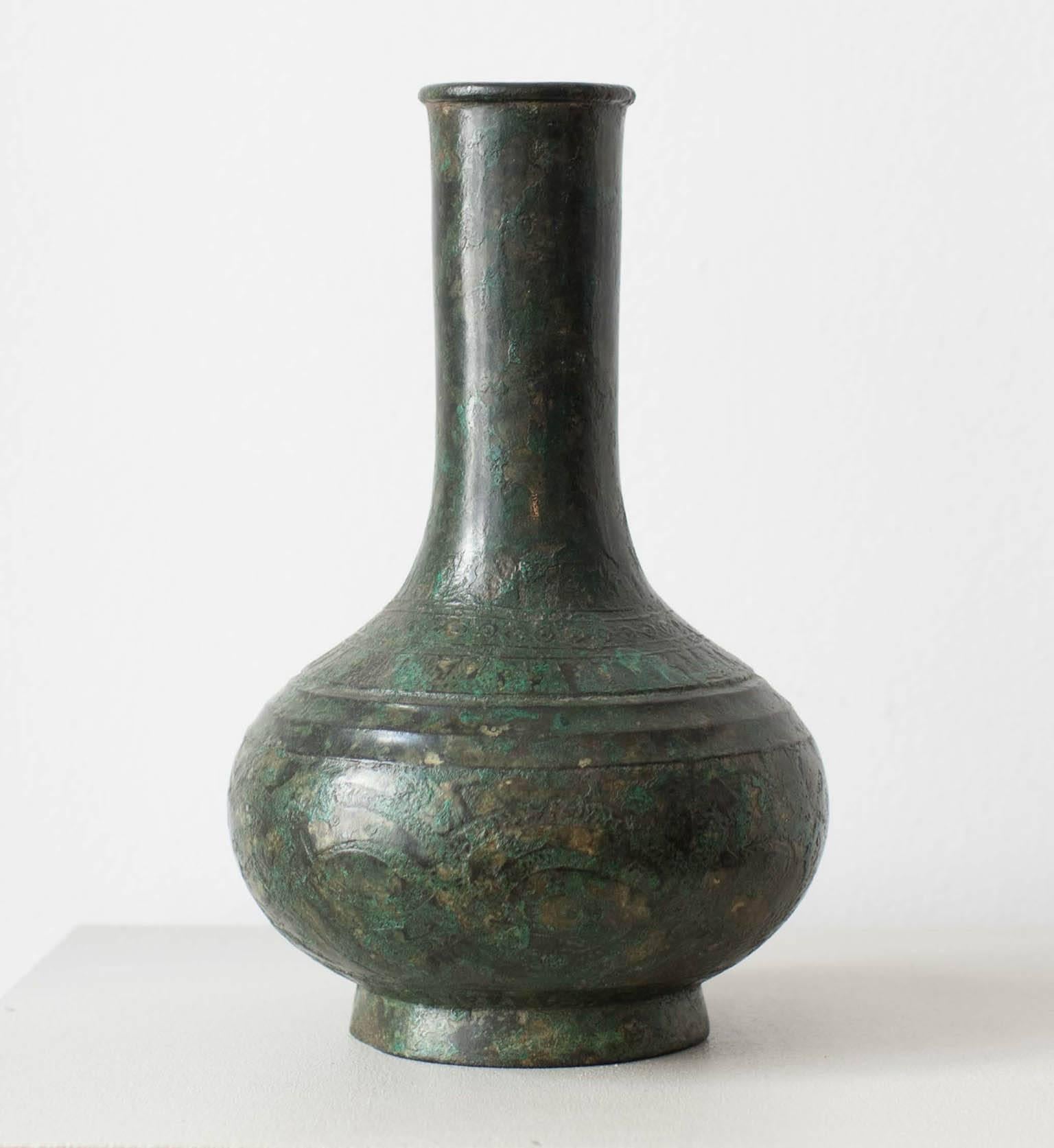 A Chinese bronze bottle vase, the shoulder and lower body with several registers of decoration above a spreading foot, the surface with rich patina, Qing dynasty 18th/19th century. 

Provenance: Private Collection. Spink and Son Ltd., London 1958.
 