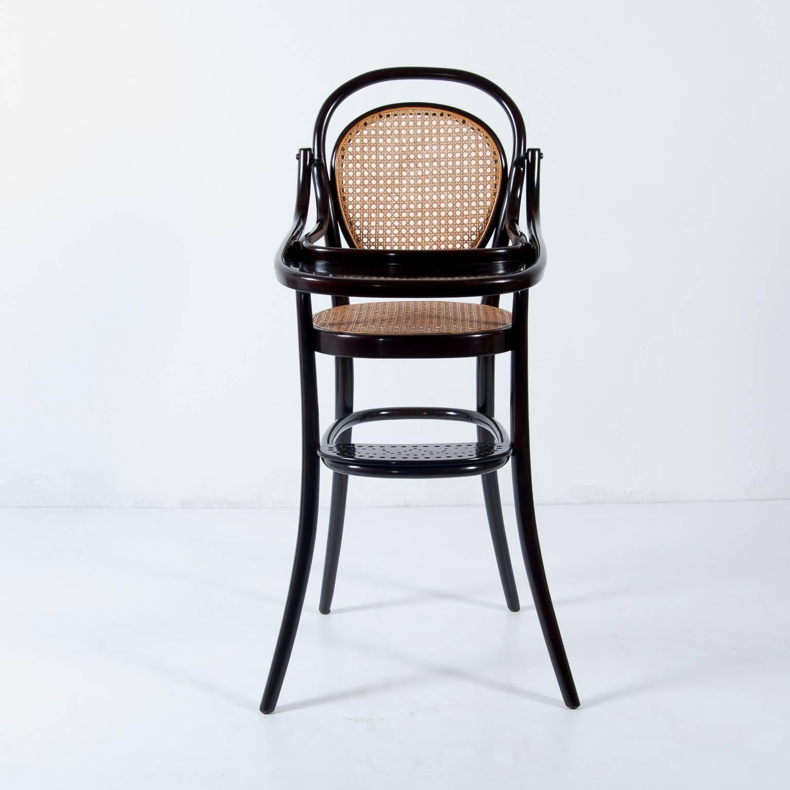 Thonet re-edition of the No. 3 children highchair with tableau.
Originally designed, circa 1900.
Date of manufacture, circa 1970.
Mahogany stained beech bentwood. 
Wickerwork in perfect, ready to use condition.
With Thonet label.
Newly restored.