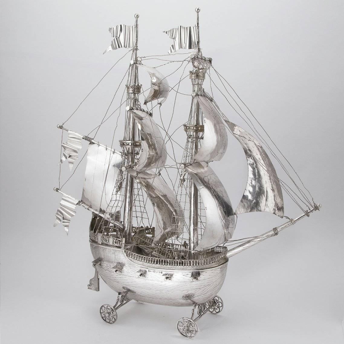 This wonderful silver nef, or centerpiece in the form of a galleon, is beautifully handmade with engraved and chased detail to show the wood grain and windows on the hull. It has four protruding cast cannons on each side, a hinged rudder in the form