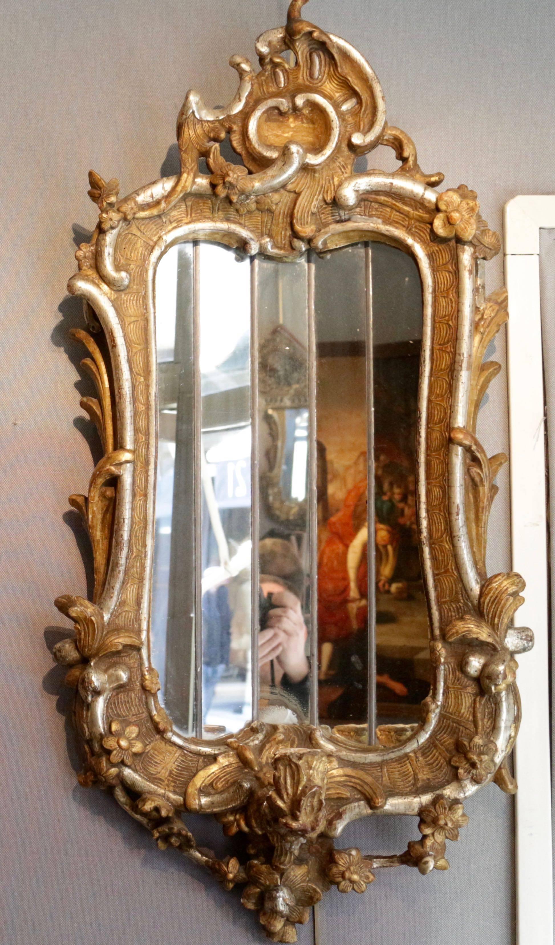 Fantastic and rare pair of Italian mirrors, giltwood and silvered wood, mid-18th century,
with candle holders.
Each convex mirror is made of five-faceted mirror plates in order to reflect the candlelight five times.
Some of the mirror plates are