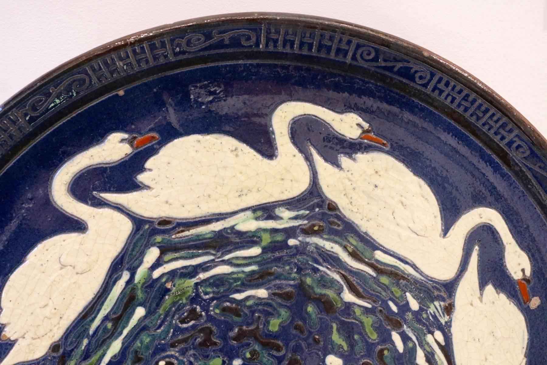 Rare sandstone enameled dish by Paul Jacquet with a Decor of Swans, circa 1915,
Paul Jacquet (1883-1968).

Paul Jacquet was born in Pers on Jussy on 23 June 1883. After a happy childhood, he became a teacher, like his father, while preparing the