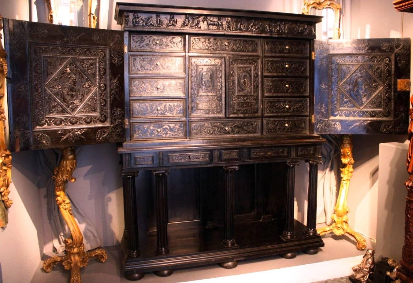 A fabulous 17th century carved ebony cabinet on stand, Paris, France, circa 1640, Louis XIII period.
This cabinet opens by two doors revealing twelve drawers and two small doors. Doors carvings depict: 