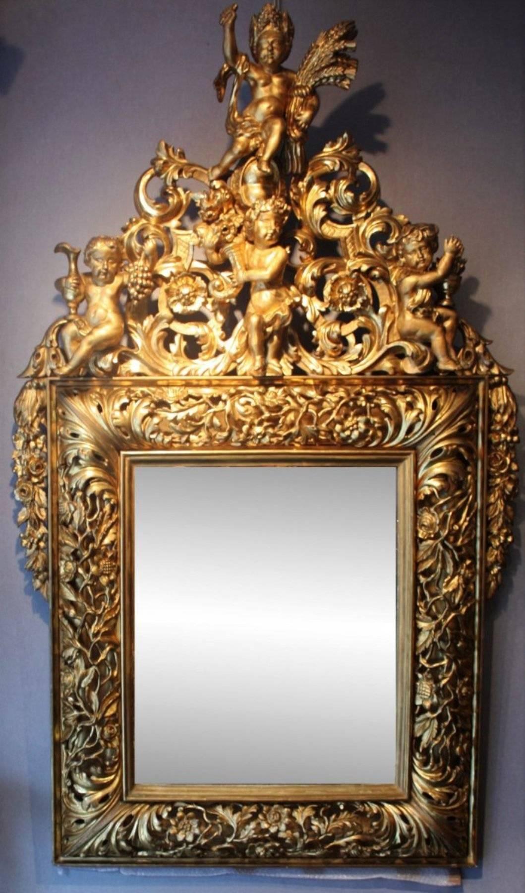 Grand 18th century Italian carved open-work giltwood mirror depicting the four seasons.
The frame is made of open-work carved giltwood decorated with flowers and leaves forming acanthus leaves scrolls. The pediment is lavishly carved and adorned