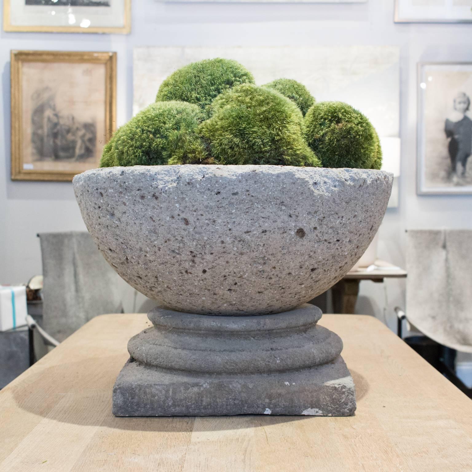 This stone centerpiece is actually made up of two separate pieces, the square base is cast stone and the bowl on top is cast hypertufa, which is an expanded stone that is slightly lighter than concrete. The bowl has been piled high with preserved