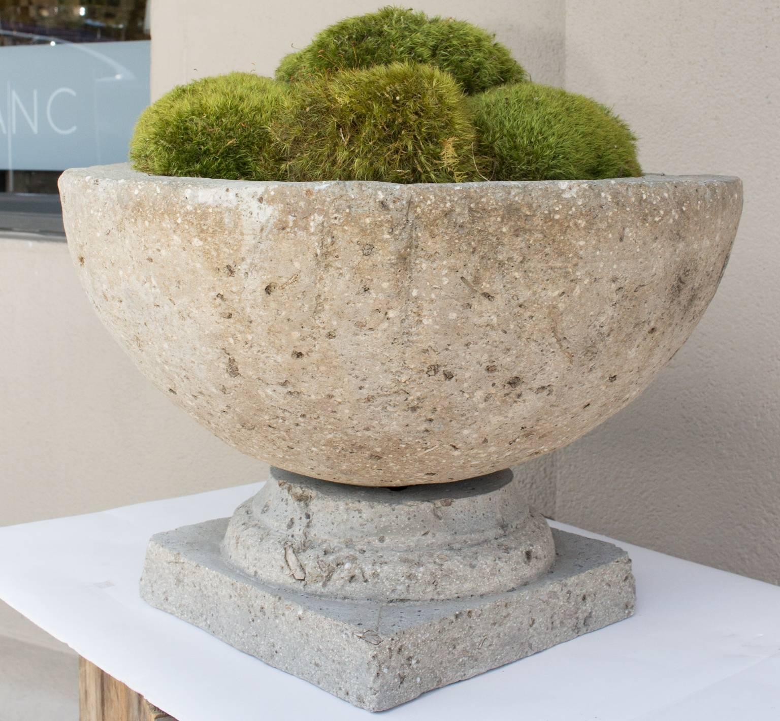 This stone centerpiece is actually made up of two separate pieces, the square base is cast stone and the bowl on top is cast hypertufa, which is an expanded stone that is slightly lighter than concrete. The bowl has been piled high with preserved