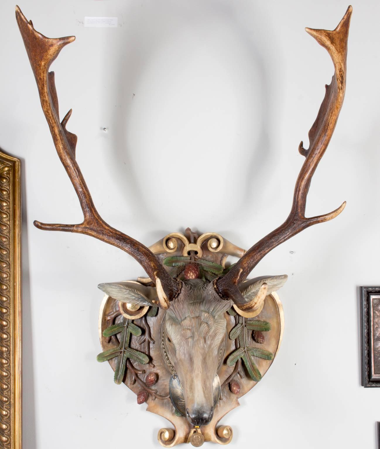 A stunning and very lifelike hand-carved linden wood Fallow deer with Italian polychrome painting technique with antique Habsburg antlers from the Eckartsau Castle of Emperor Franz Josef in the Southern Austrian Alps, a favorite hunting schloss of