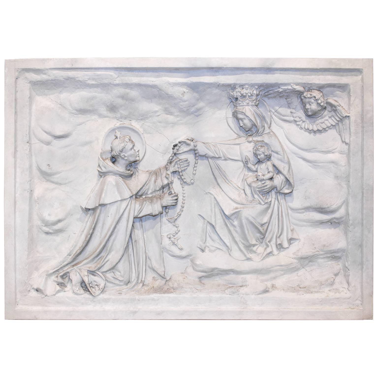 Truly a very special one of a kind large-scale religious piece dating to the early 1800s, this large plaster bas relief features the lovely iconic image of Saint Dominic receiving the Rosary from the Blessed Virgin Mary while the infant Jesus sits