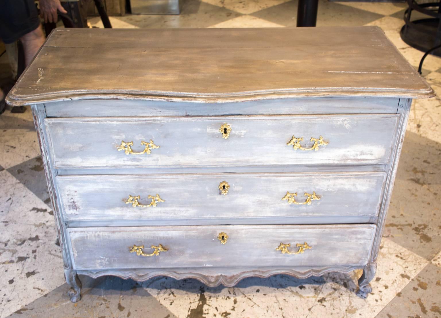 This distressed-finish chest of drawers was recently discovered in France. With three drawers, there is plenty of room for storage in this charming piece. The brass hardware looks to be original, but could easily be changed for a different finish.
