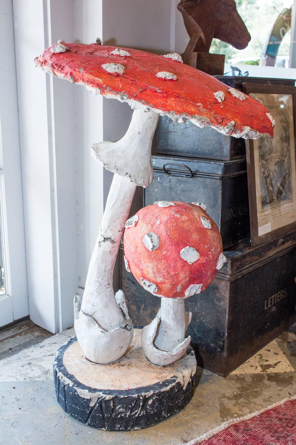 This is a pairing of midcentury faux bois mushroom sculptures found in France. Each sculpture consists of three pieces; the large mushroom, the small mushroom, and the base. The mushrooms are inserted via iron post into the base. Each piece measures