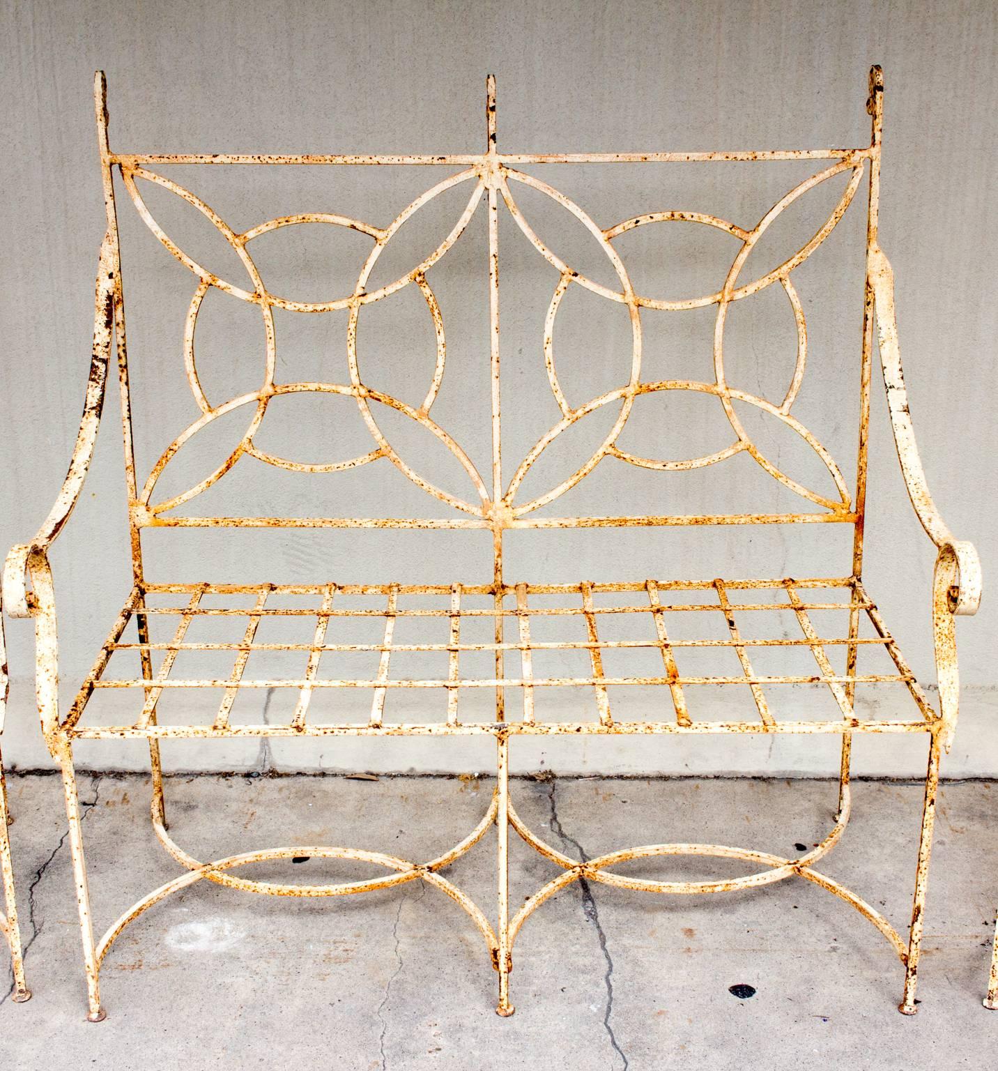 This wonderful, geometric-styled iron garden set features a pair of armchairs with a matching settee, in a distressed painted finish. The top layer of paint is a creamy ivory, and although it has seen better days, we feel the rustic finish adds even